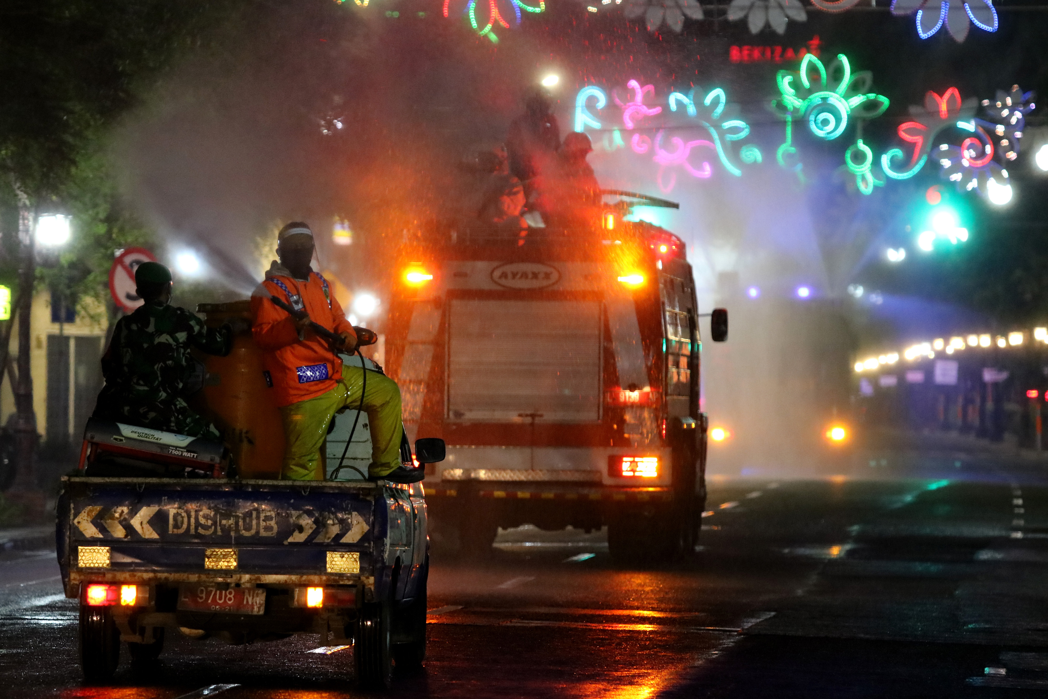 Petugas gabungan menyemprotkan larutan disinfektan di Jalan Tunjungan yang ditutup di Surabaya, Jawa Timur, Jumat (3/7).