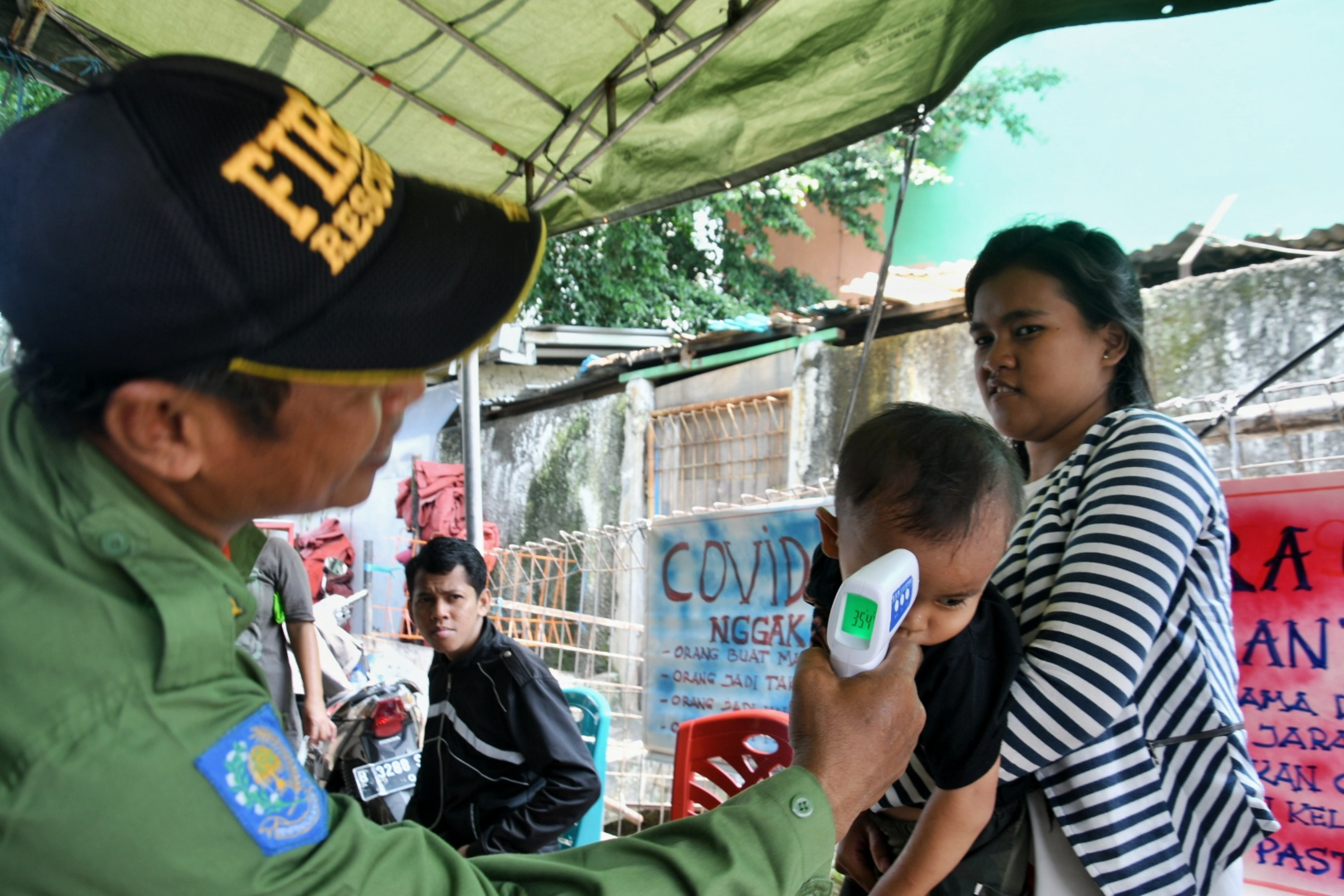 Sejumlah warga mengikuti prosedur sebelum masuk kawasan RT.15 RW.07 Tanjung Duren Utara, Jakarta Barat, Rabu (1/4/2020).