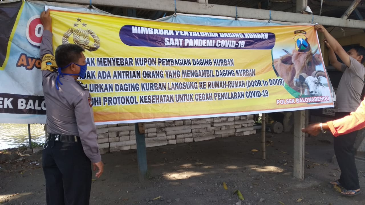 Polisi memasang himbauan dalam melaksanakan kurban. 
