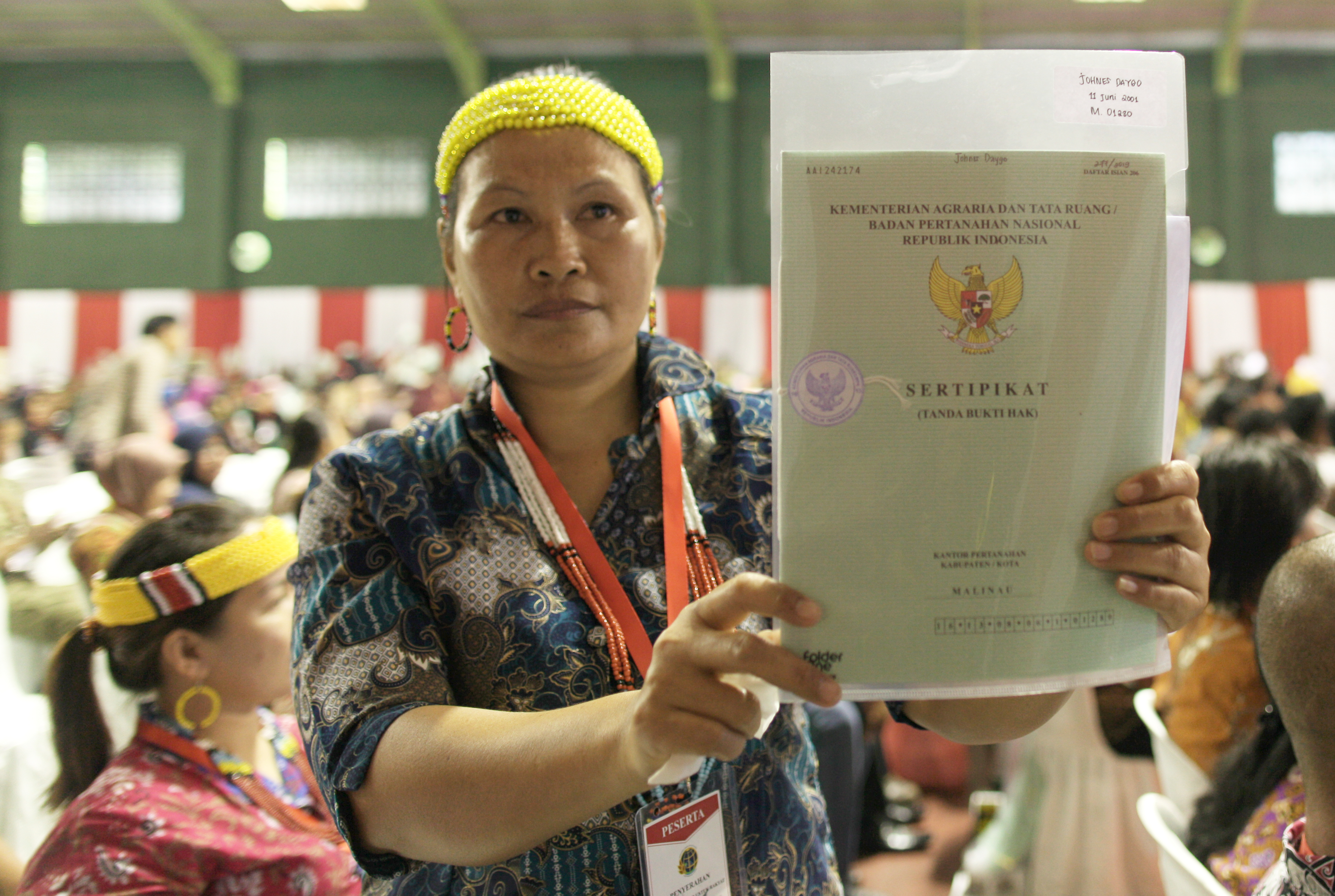 Seorang warga menunjukan sertifikat tanah gratis yang dibagikan Presiden Jokowi di Lapangan Tenis Indor Telaga Keramat, Tarakan, Kalimantan 