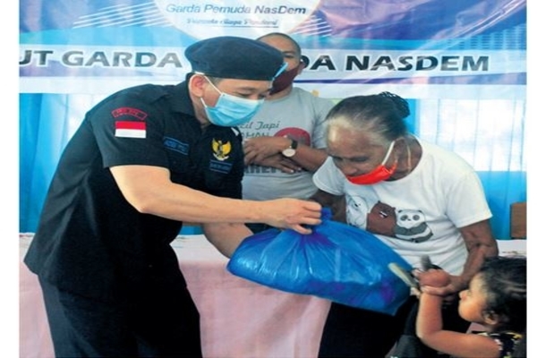 Ketua Dewan Pimpinan Wilayah (DPW) Garda Pemuda (GP) NasDem NTT, Bobby Pitoby, menyerahkan paket sembako kepada warga di Kelurahan Maulafa, 