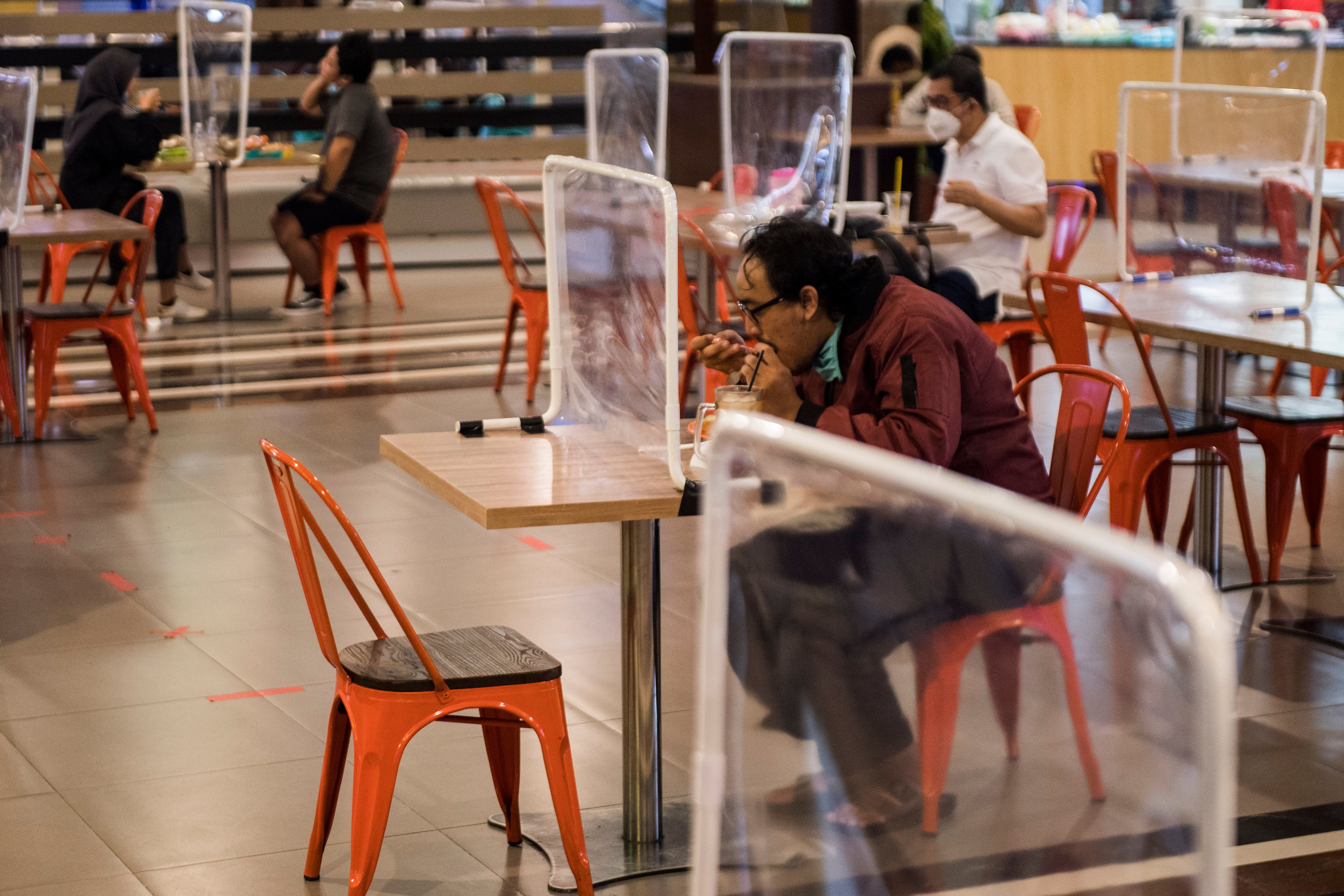 Pengunjung food court menikmati makanan dengan tetap menerapkan protokol kesehatan.