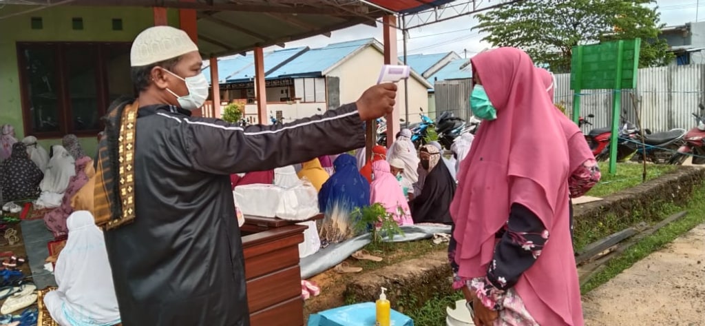 Petugas memeriksa suhu tubuh peserta salat Idul Adha berjamaah di sebuah musala di Kota Sorong, Papua Barat, Jumat (31/7/2020)