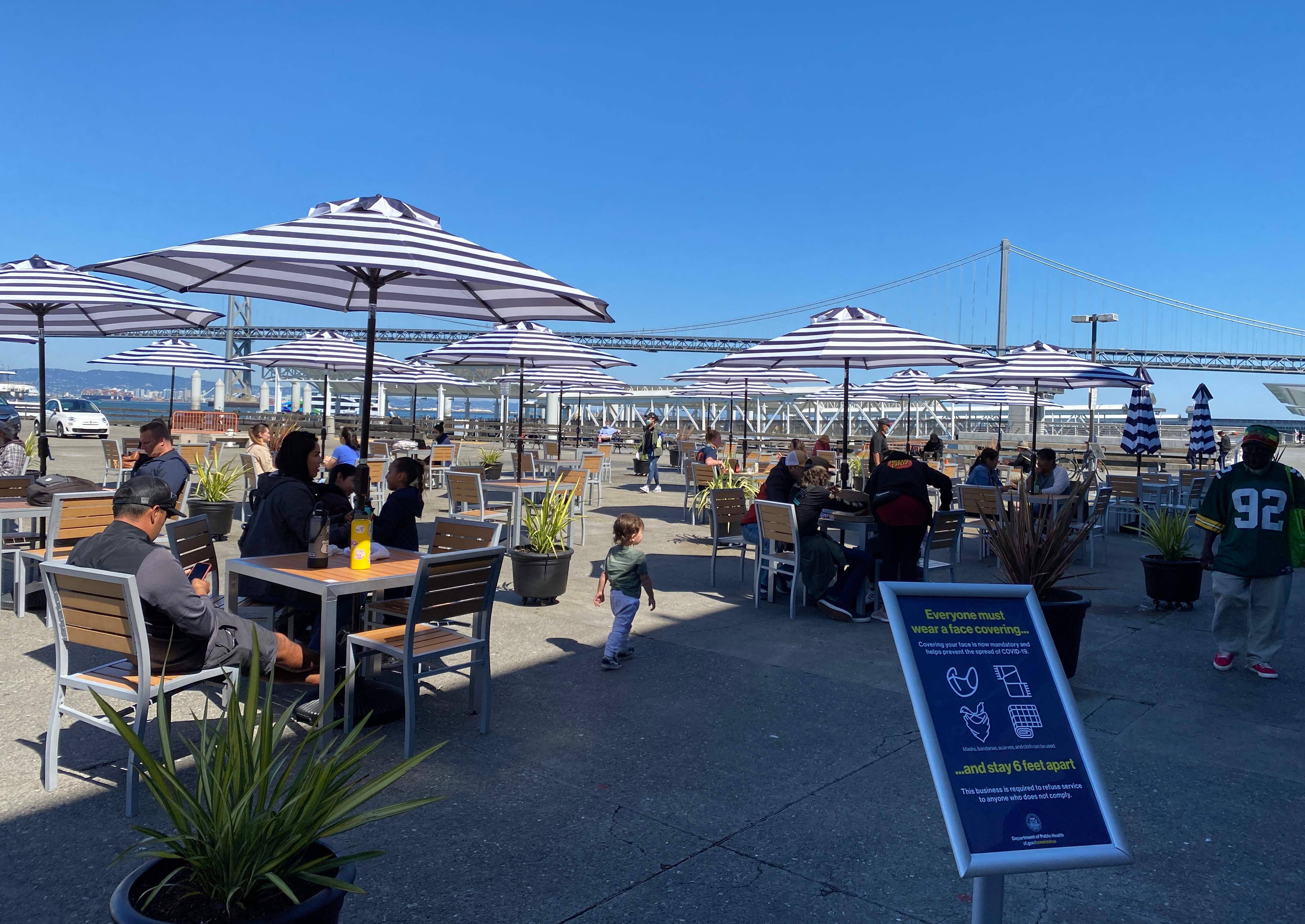 Ada pengumuman protokol kesehatan di area makan di San Francisco Pier (30/7/2020)