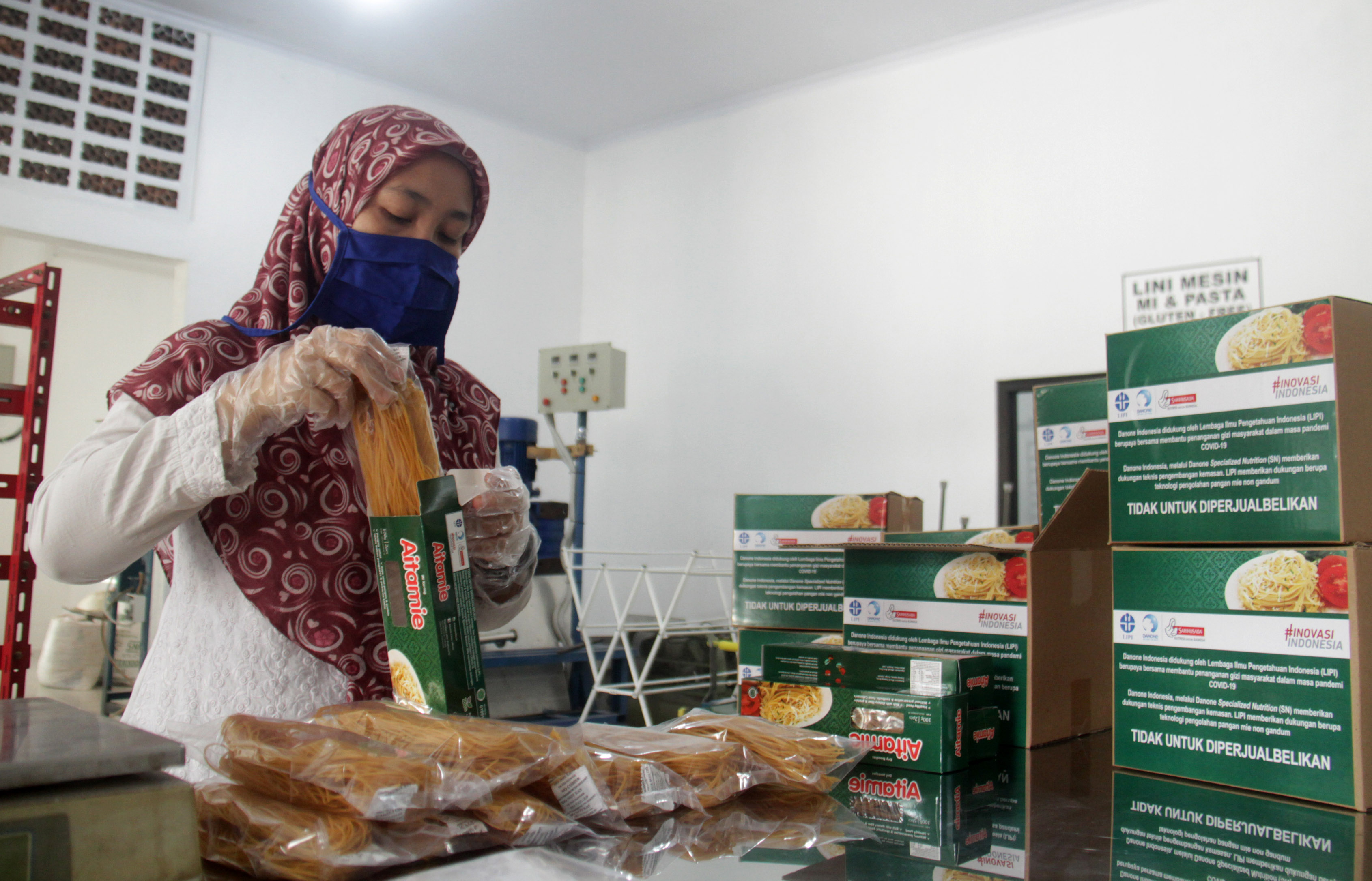 Seorang pekerja tengah memasukan Aitamie ke dalam kemasan kardus. 