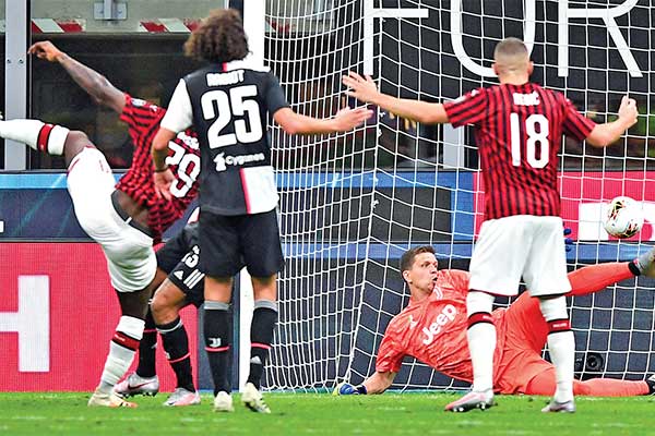 Gelandang AC Milan Franck Kessie (kiri) melesakkan bola ke gawang tanpa bisa dibendung kiper Juventus Wojciech Szczesny