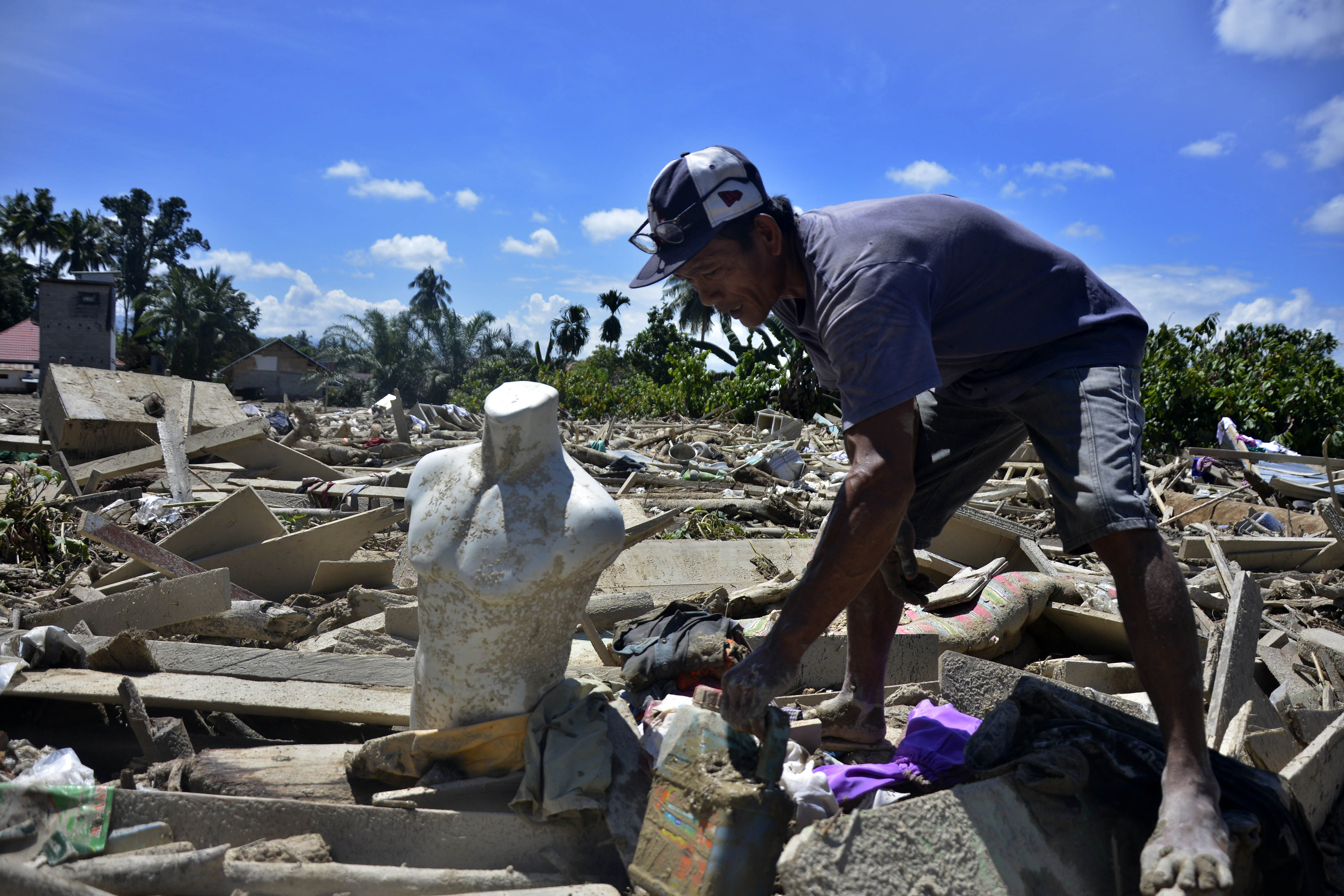 Warga mencari barangnya pasc banjir bandang di Desa Radda, Kabupaten Luwu Utara, Sulawesi Selatan.