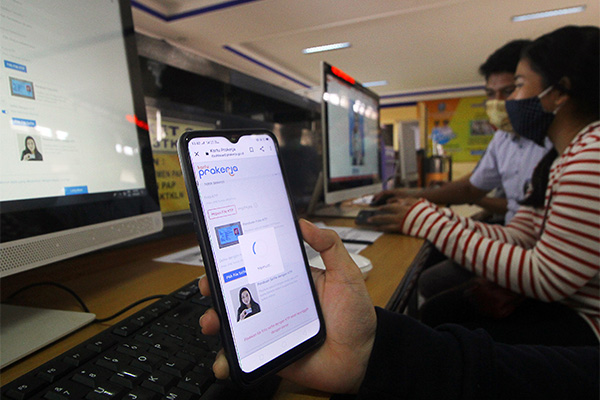 Petugas mendampingi warga yang melakukan pendaftaran calon peserta kartu rakerja di LTSA-UPT P2TK Surabaya, Jawa Timur, Senin (13/4/2020)