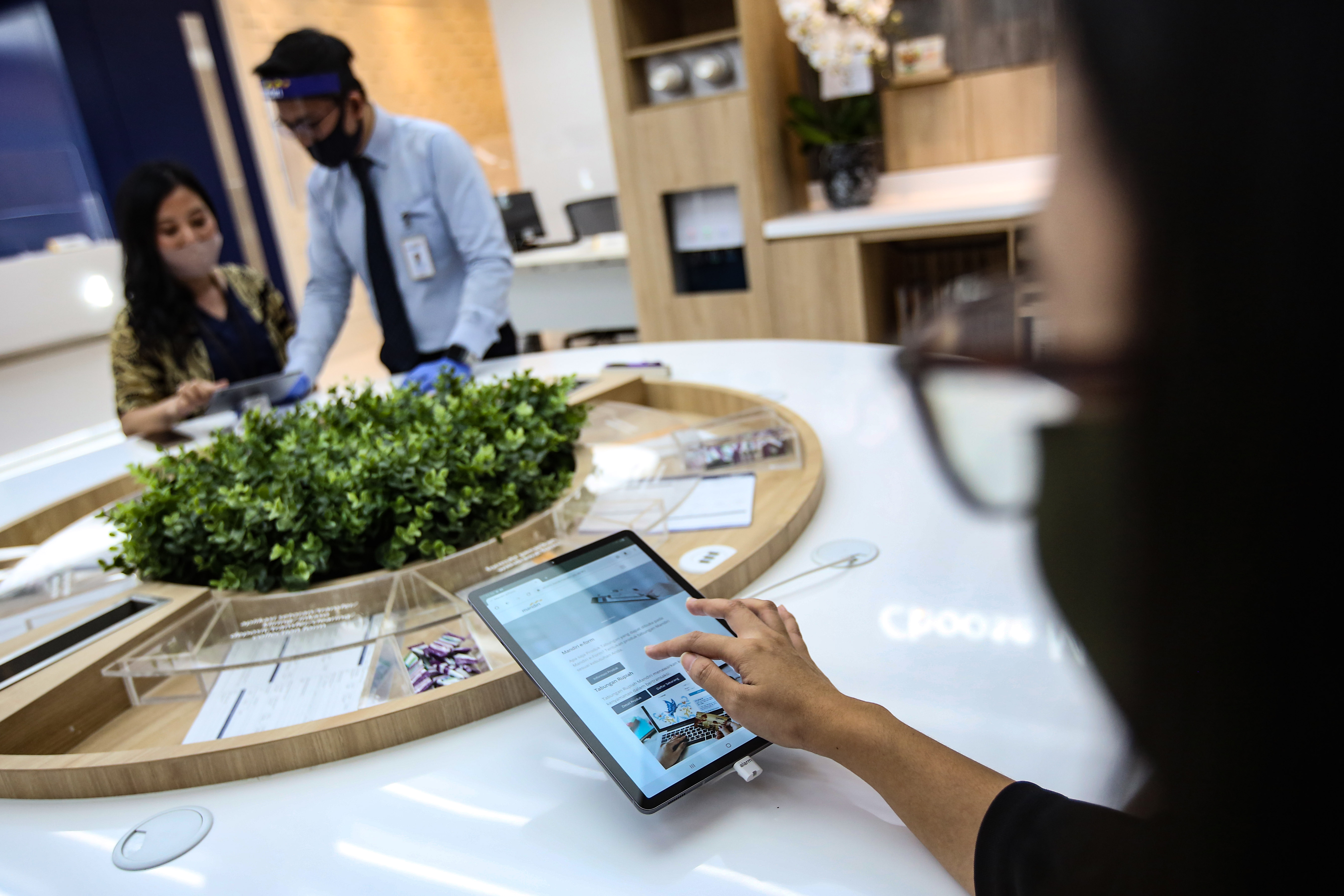 Nasabah melakukan transaksi digital di kantor cabang bank.