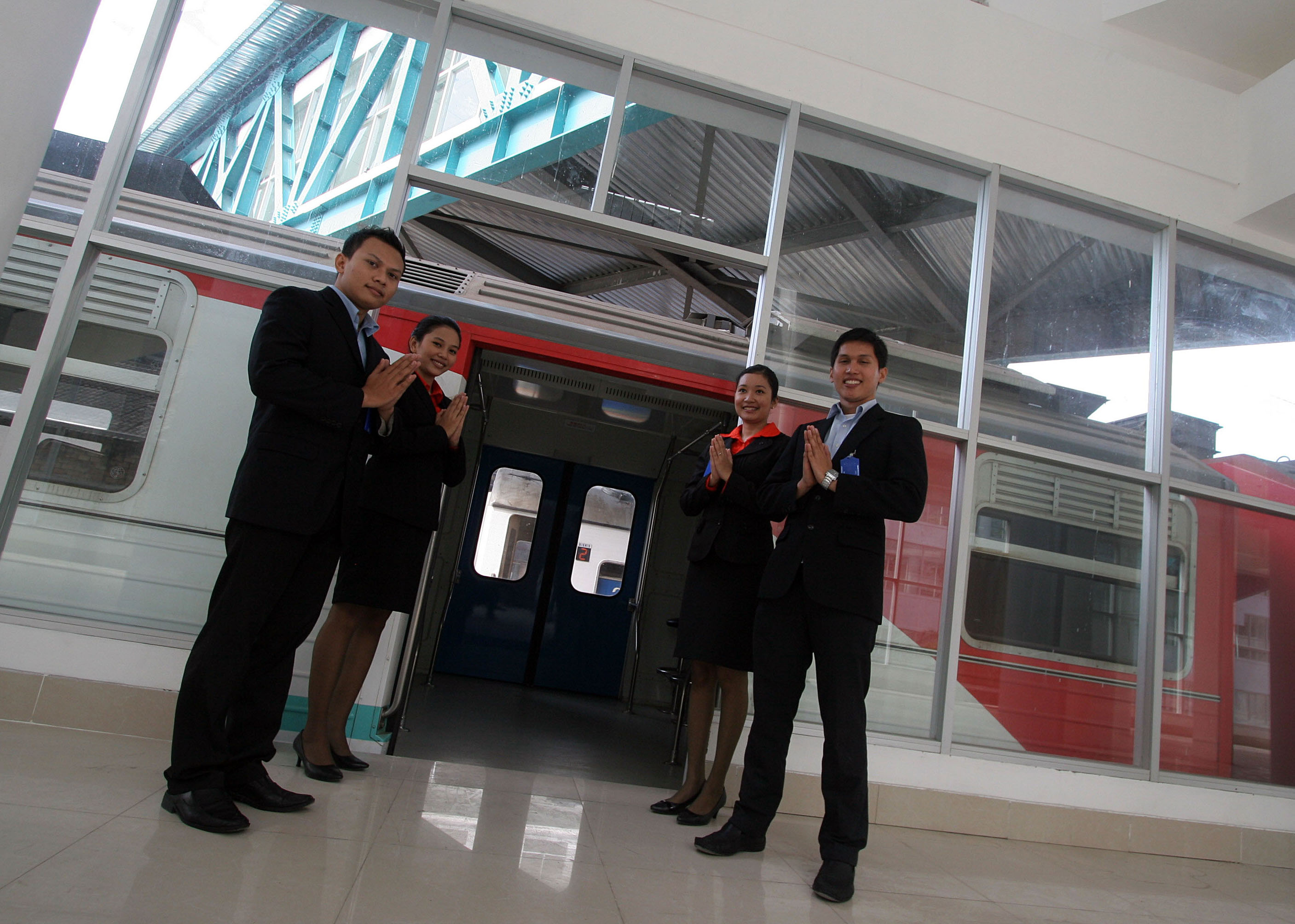 Sejumlah petugas kereta api bandara menyambut kedatangan penumpang pada sosialisasi pengoperasian KA Bandara Kualanamu, di Medan