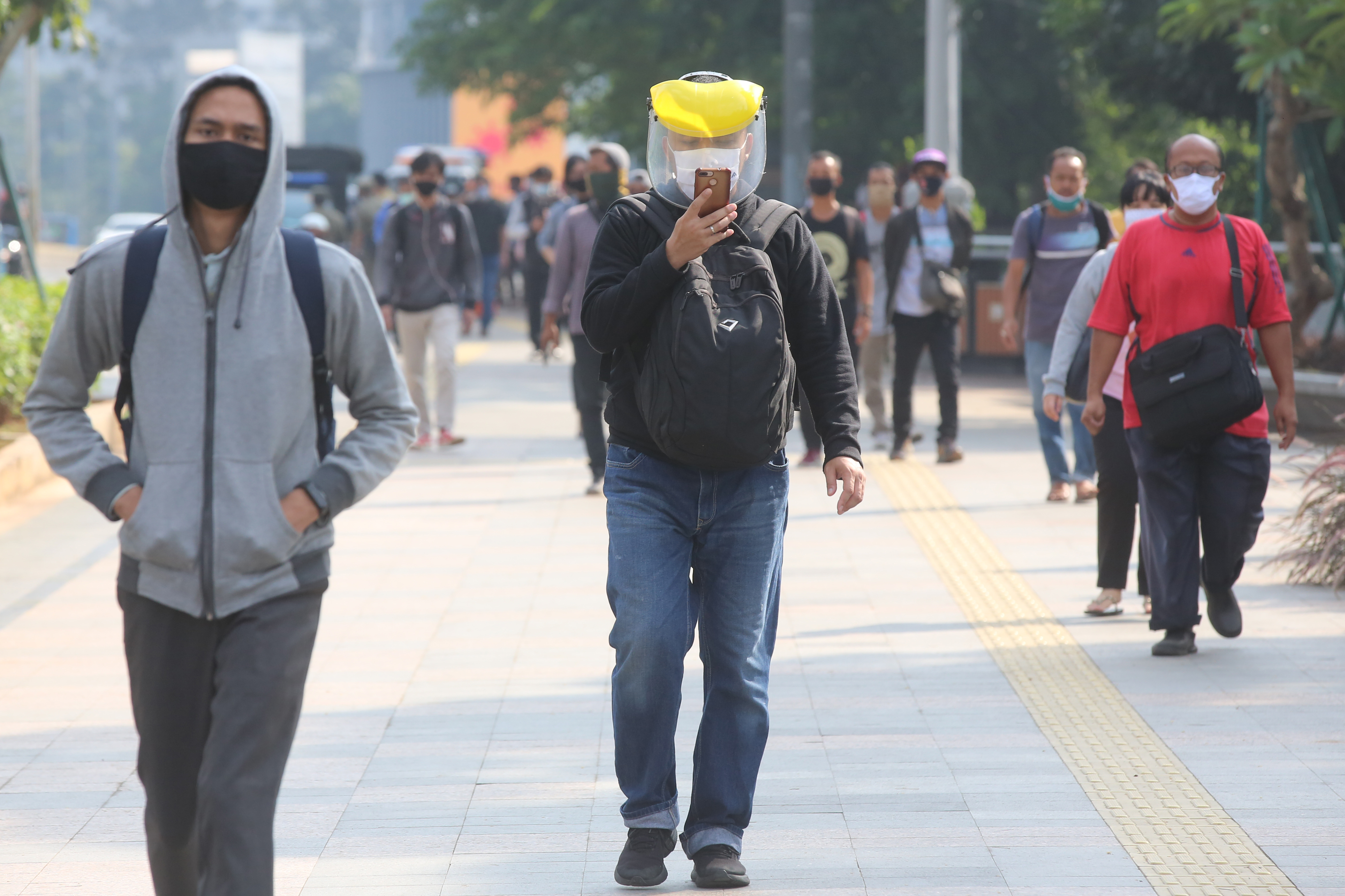 Pekerja berjalan di kawasan Jl. Sudirman Jakarta.