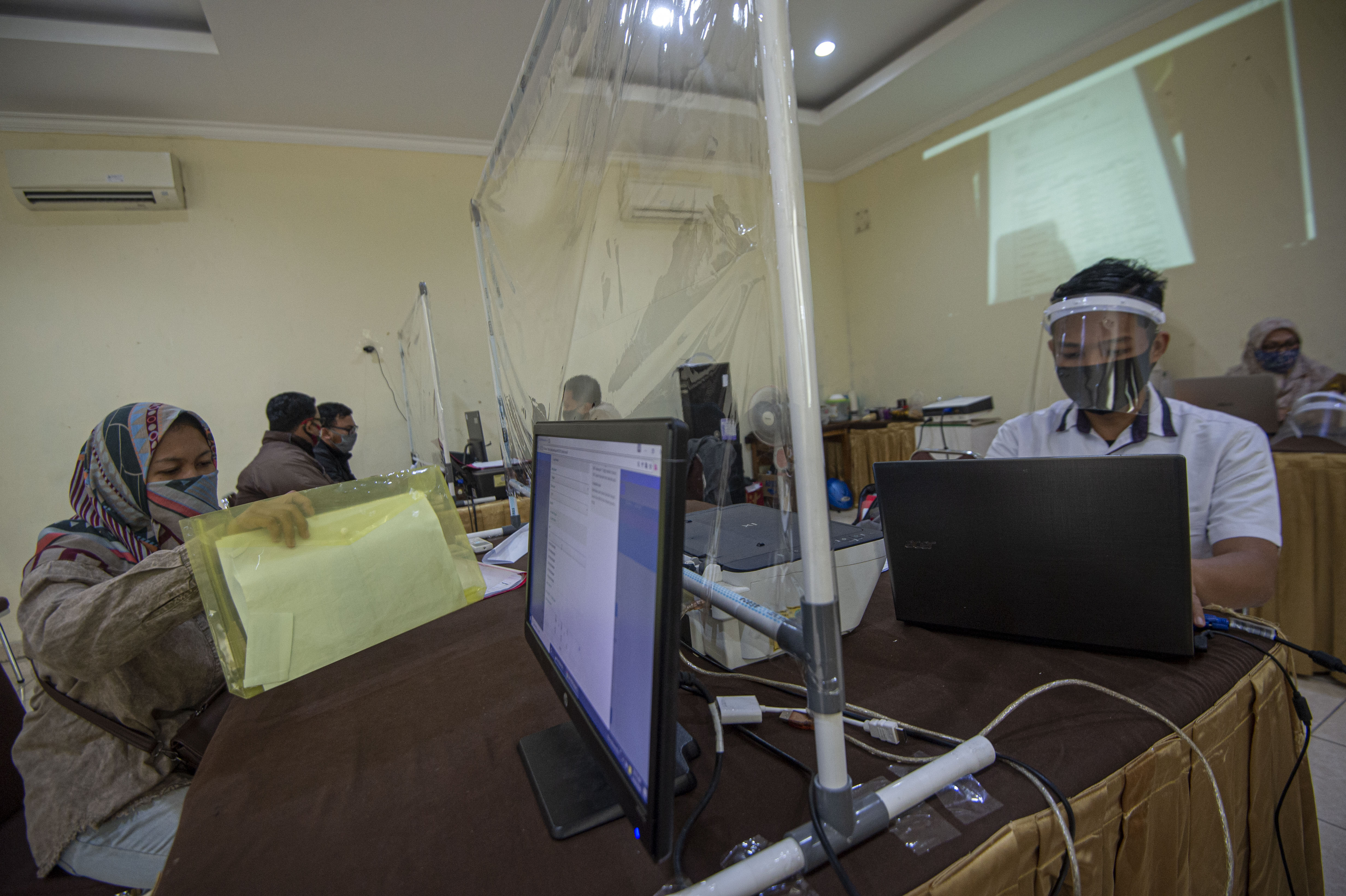 LAPOR DIRI: Petugas melayani warga yang melaporkan anaknya usai lolos dalam PPDB 2020/2021 di Posko Pelayanan PPDB DKI