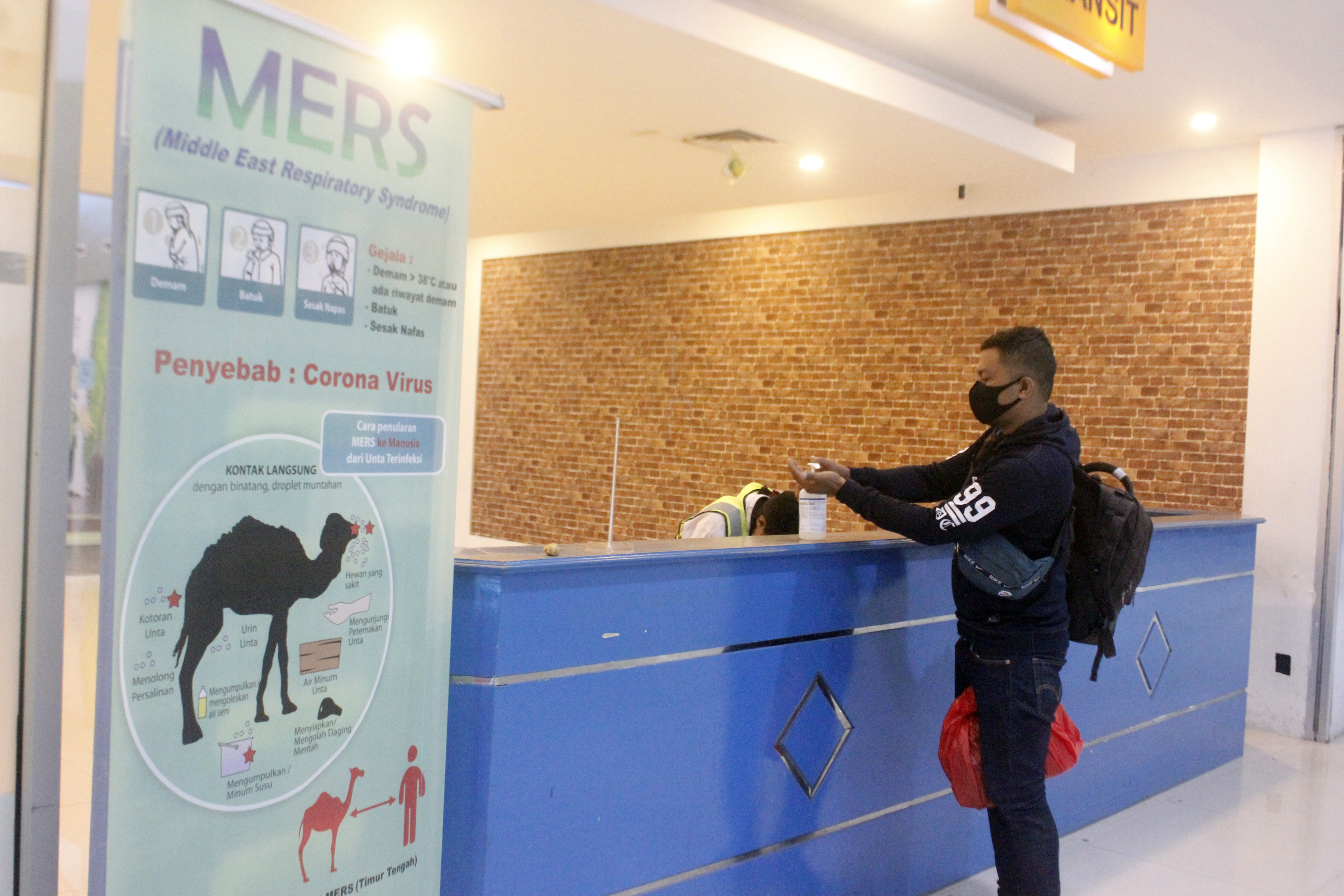 Seorang calon penumpang pesawat menggunakan hand sanitizer yang disediakan pihak Bandara Domine Eduard Osok (DEO) Kota Sorong, Papua Barat.