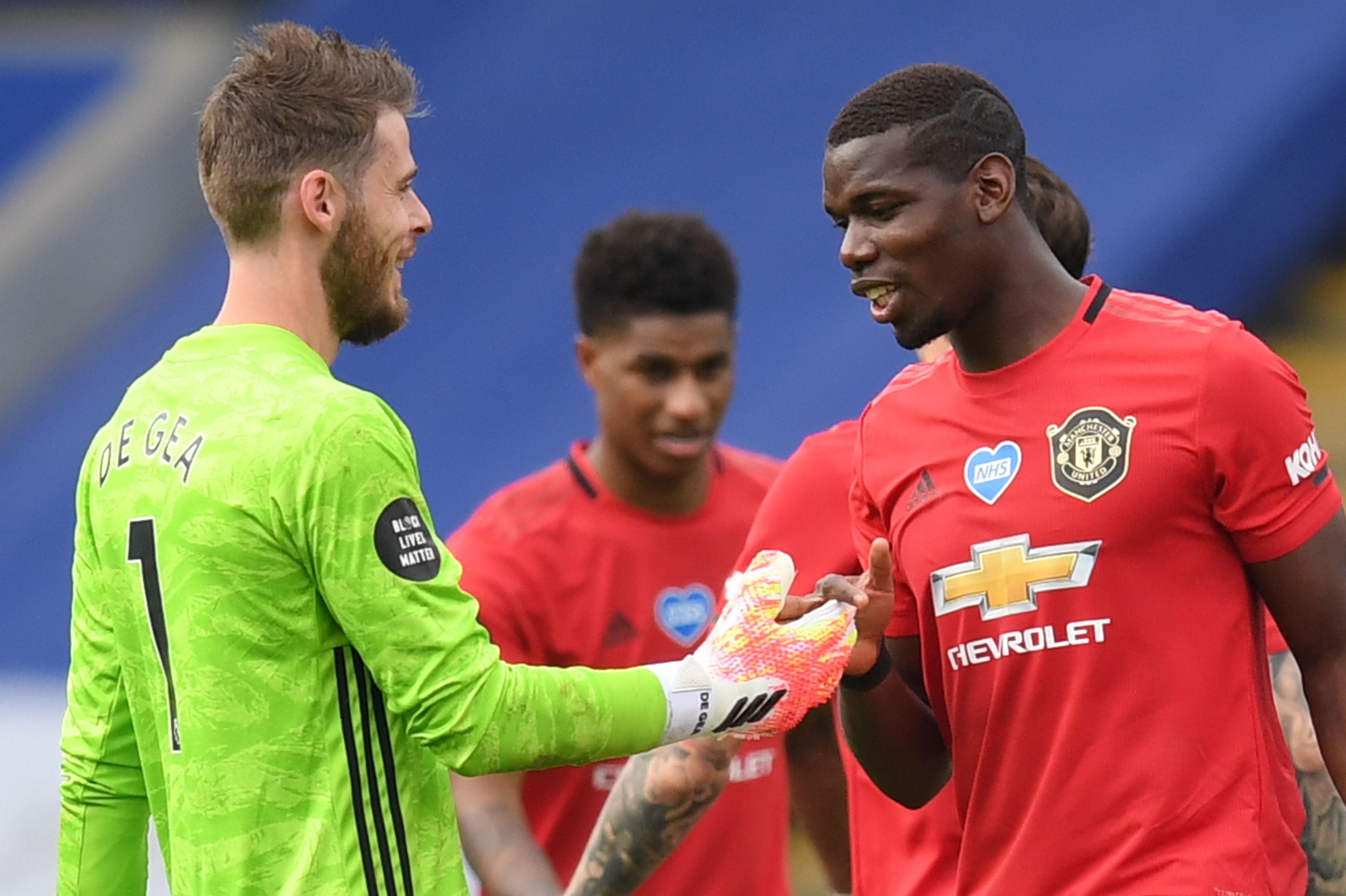 Kiper David De Gea (kiri) dan Paul Pogba bersalaman usai membawa Manchester United menang 2-0 atas Leicsster City, Minggu (26/7).  