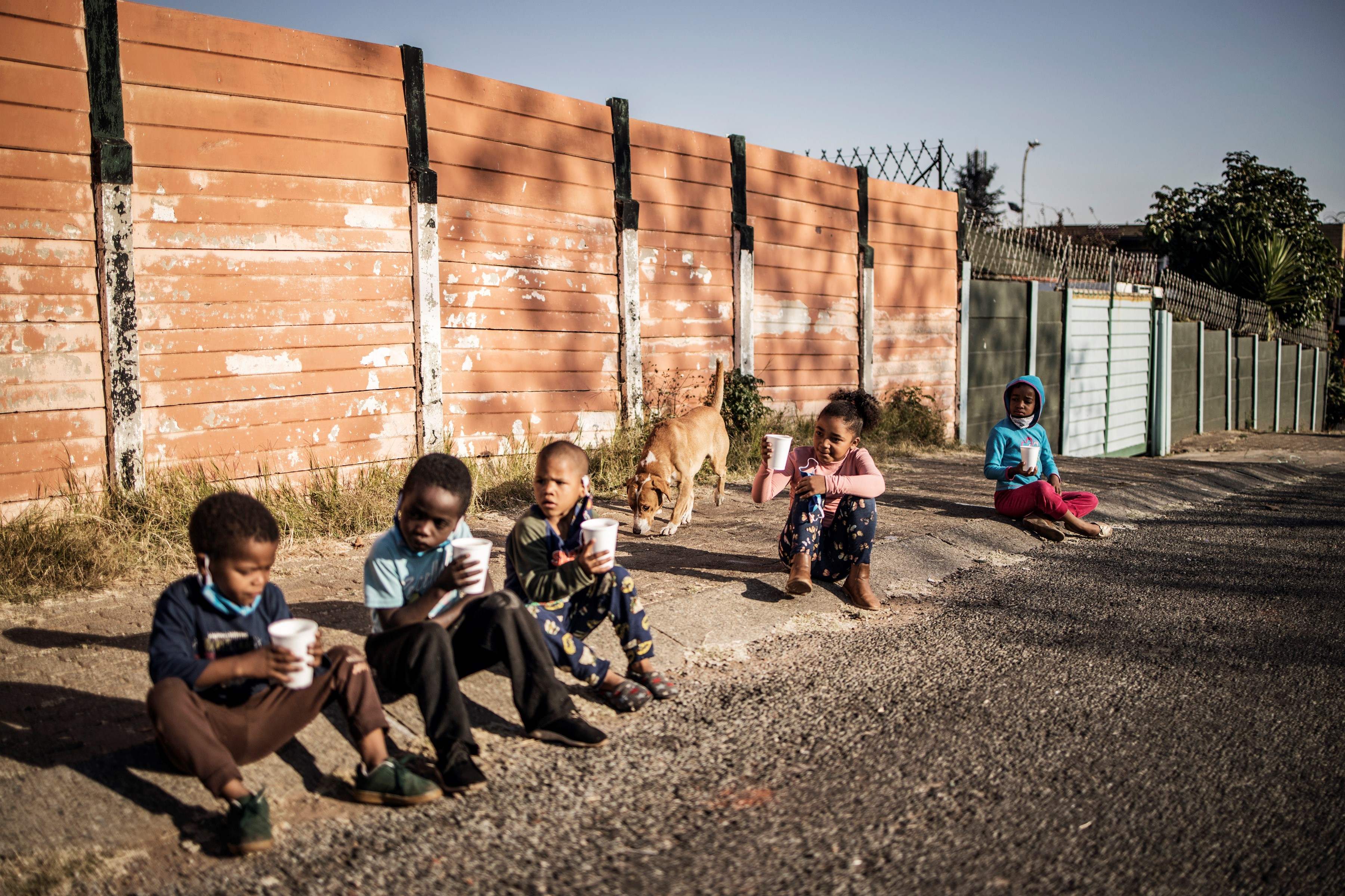 Anak-anak terdampak pandemi covid-19 memakan bubur bantuan dari organisasi nirlaba di Johannesburg, Afrika Selatan, (23/5). 
