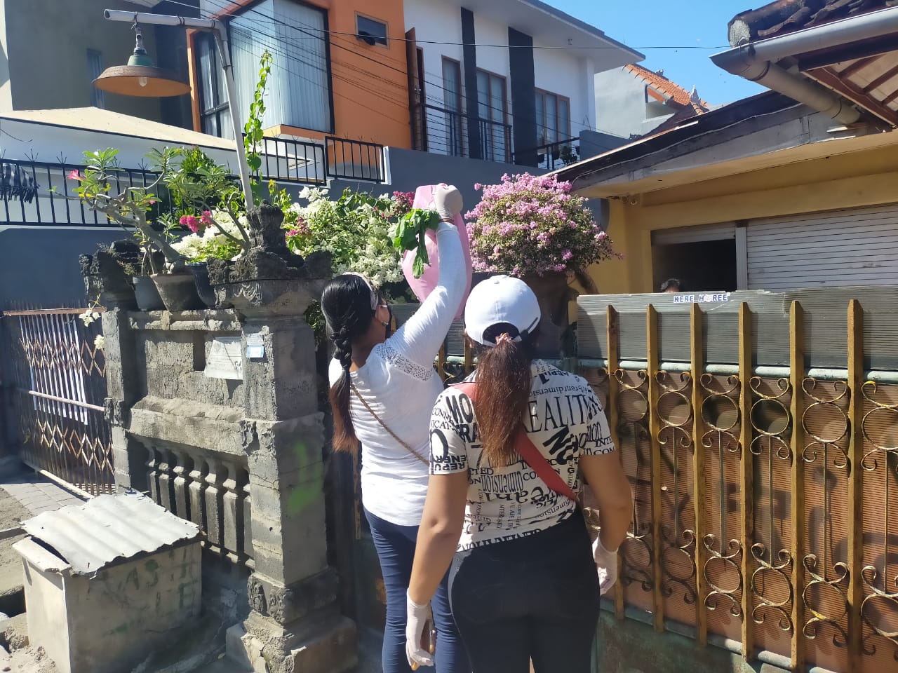 Warga memberikan bantuan sembako kepada warga Gang Tegalwangi, Desa Sesetan, Bali, yang tengah menjalani isolasi mandiri.