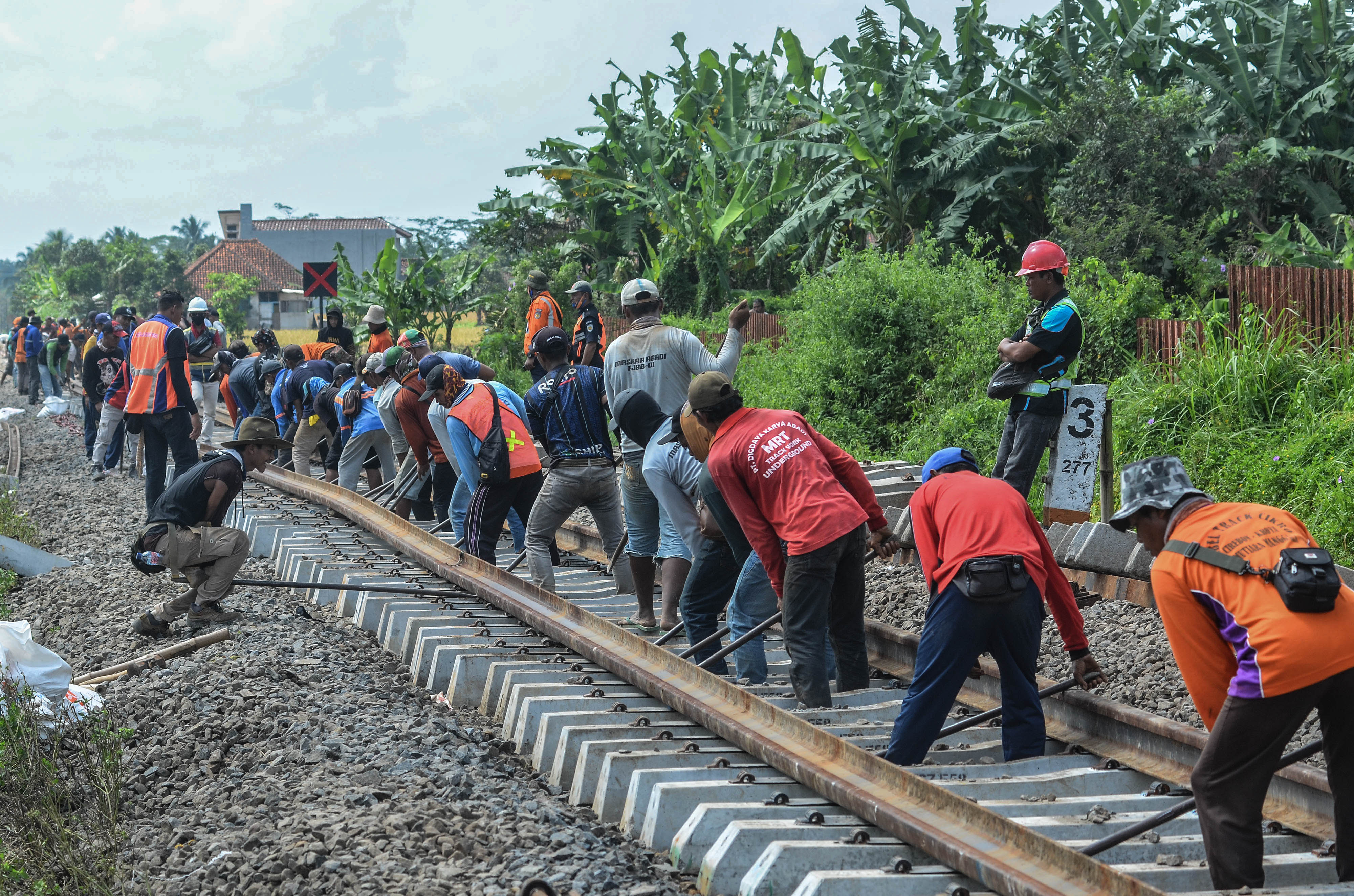 Sejumlah pekerja memasang bantalan rel baru di jalur lintasan kereta api.