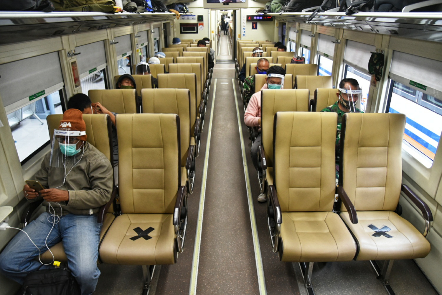 Para penumpang KA Kertajaya Jakarta-Pasar Turi memakai pelindung wajah dan masker berangkat dari Stasiun Pasar Senen, 10 Mei 2020.