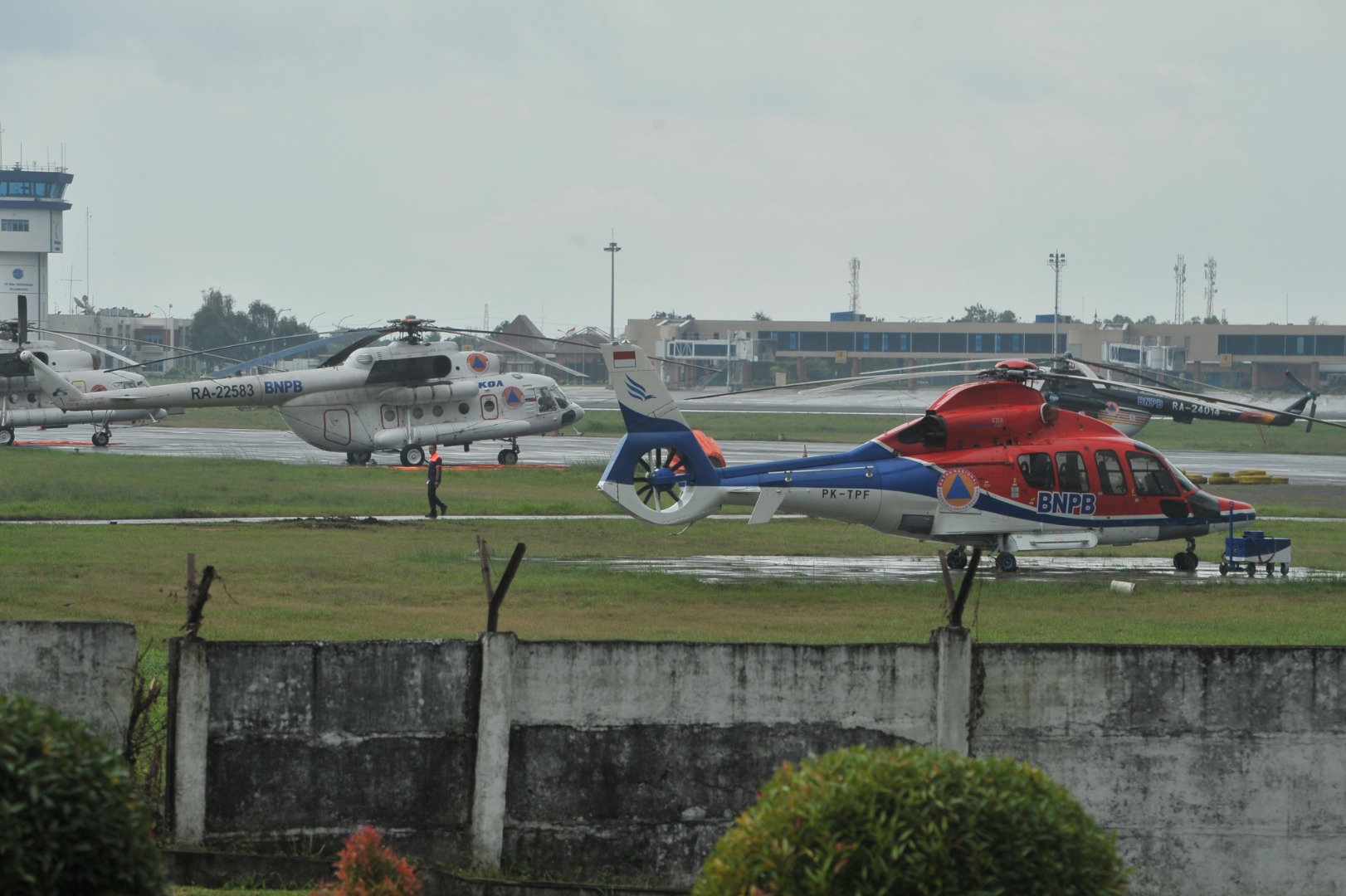 Personel Angkatan Udara melintasi helikopter water bombing di Pangkalan Udara Sri Mulyono Herlambang (Lanud SMH) Palembang, Kamis (23/7).(