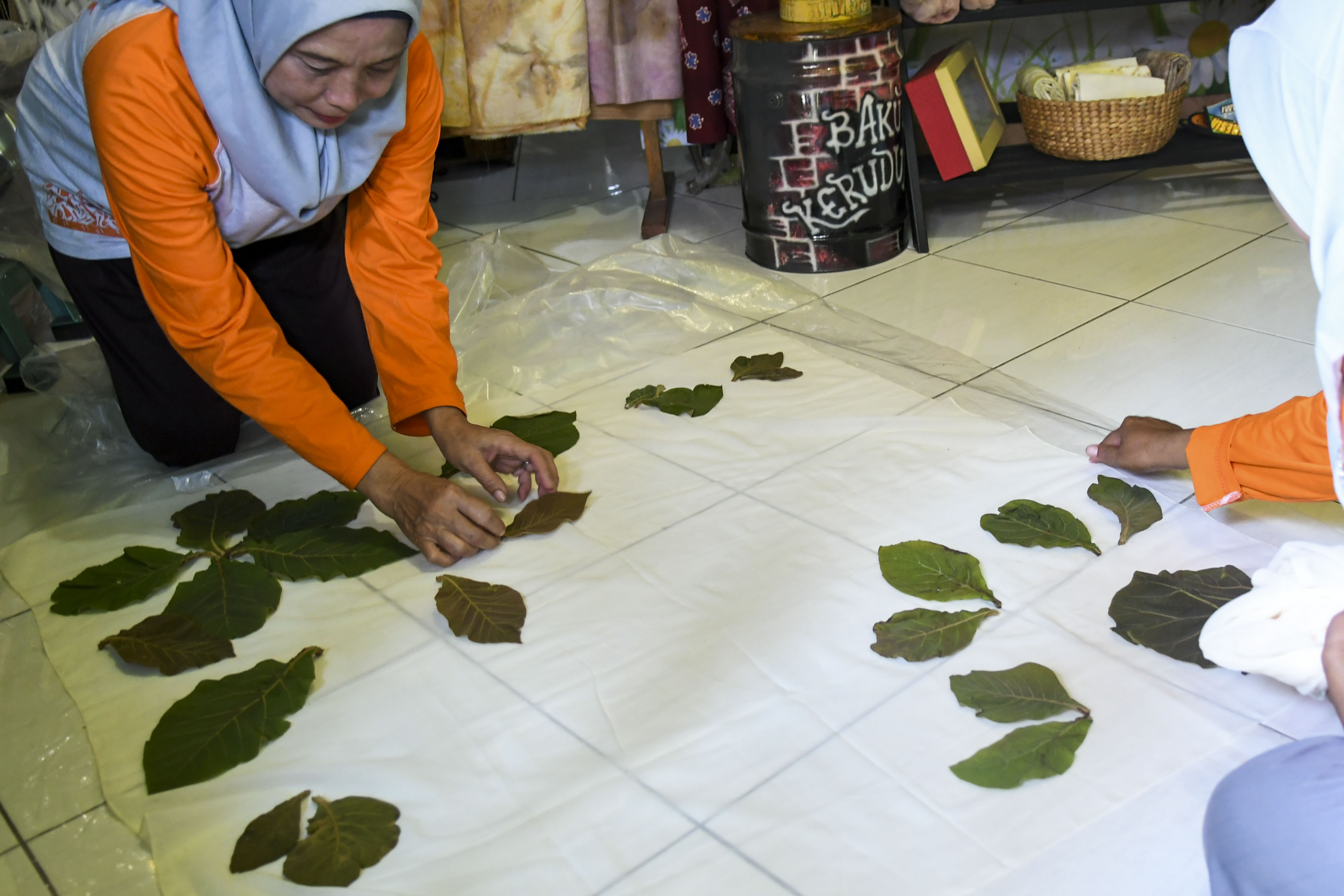 Pelaku usaha UMKM sedang menyelesaikan produk kerajinan. 