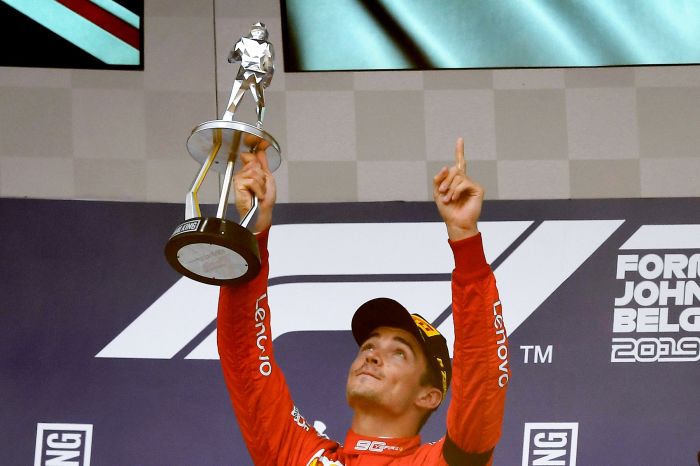 Charles Leclerc mengangkat piala dan menunjukkan jari ke atas saat memenangi Grand Prix Belgia, Minggu (2/9) malam.