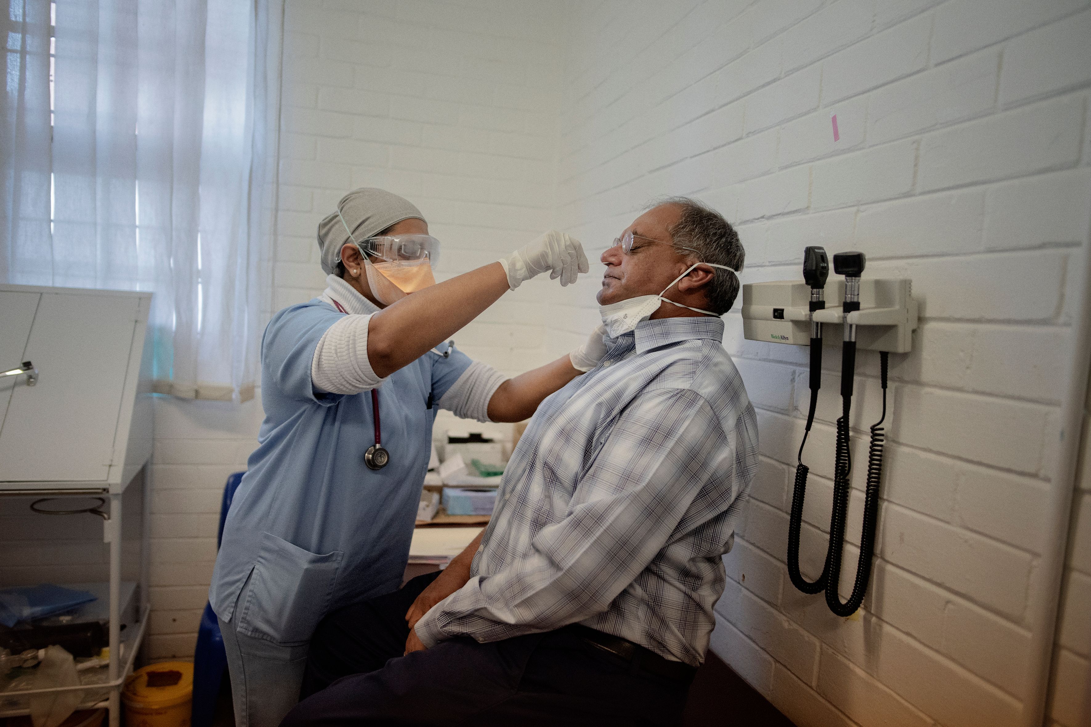 Seorang petugas melakukan tes swab covid-19 di Soweto, Afrika Selatan.