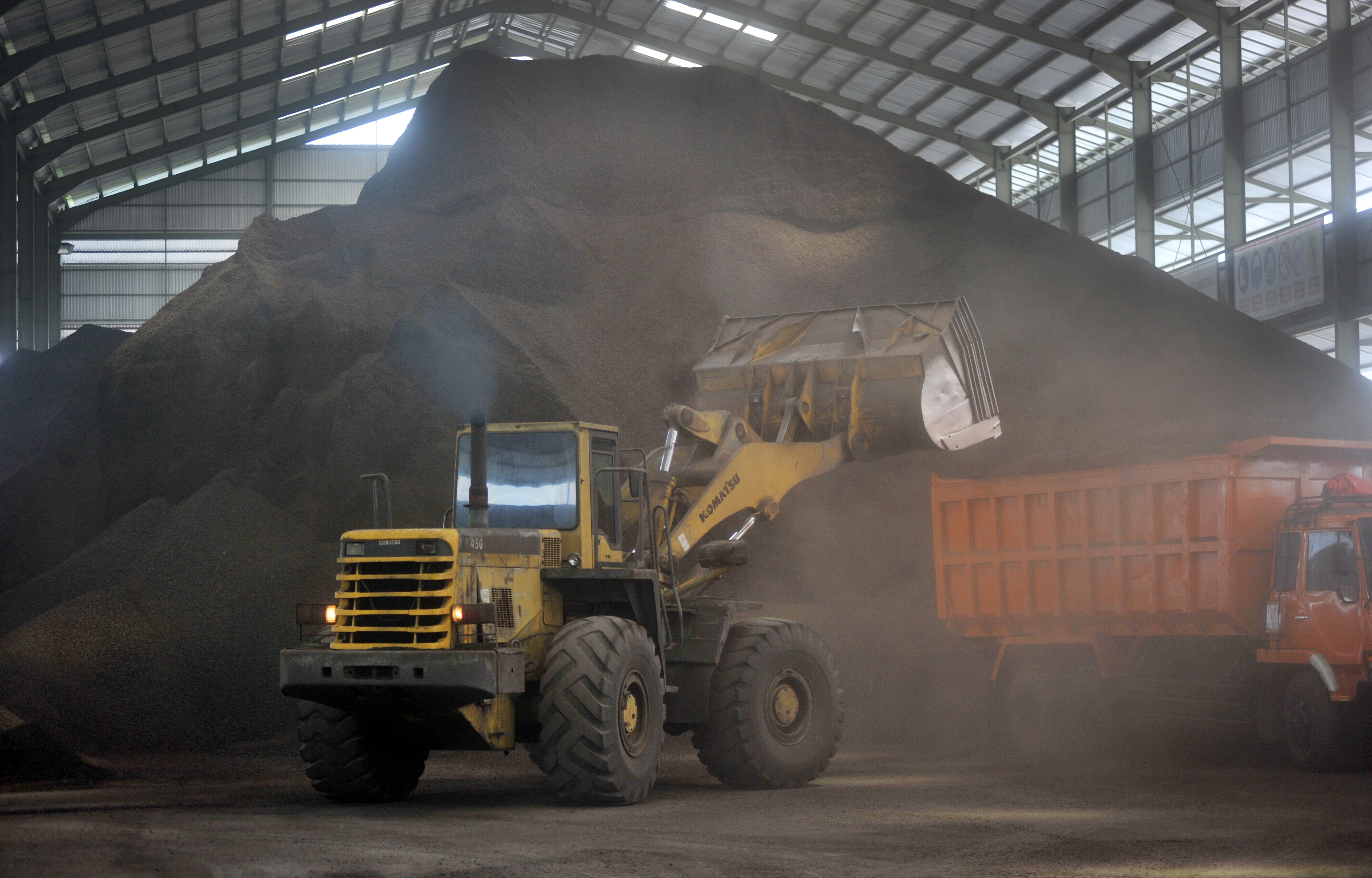 Ilustrasi: Pekerja menjalankan eskavator memindahkan komoditas ekspor cangkang sawit, di CV Pinang Mas Energy, di Padang