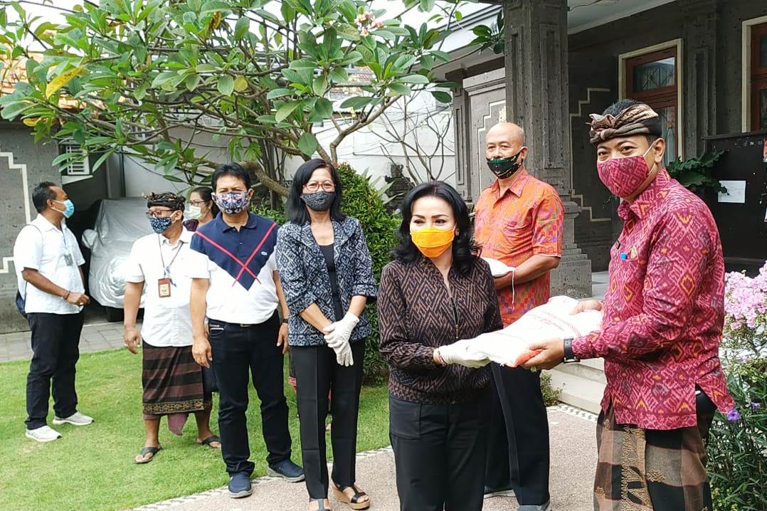 Ketua Dekranasda Kota Denpasar, Selly Mantra menyerahkan bantuan beras kepada perwakilan perajin terdampak Covid-19 di Denpasar.