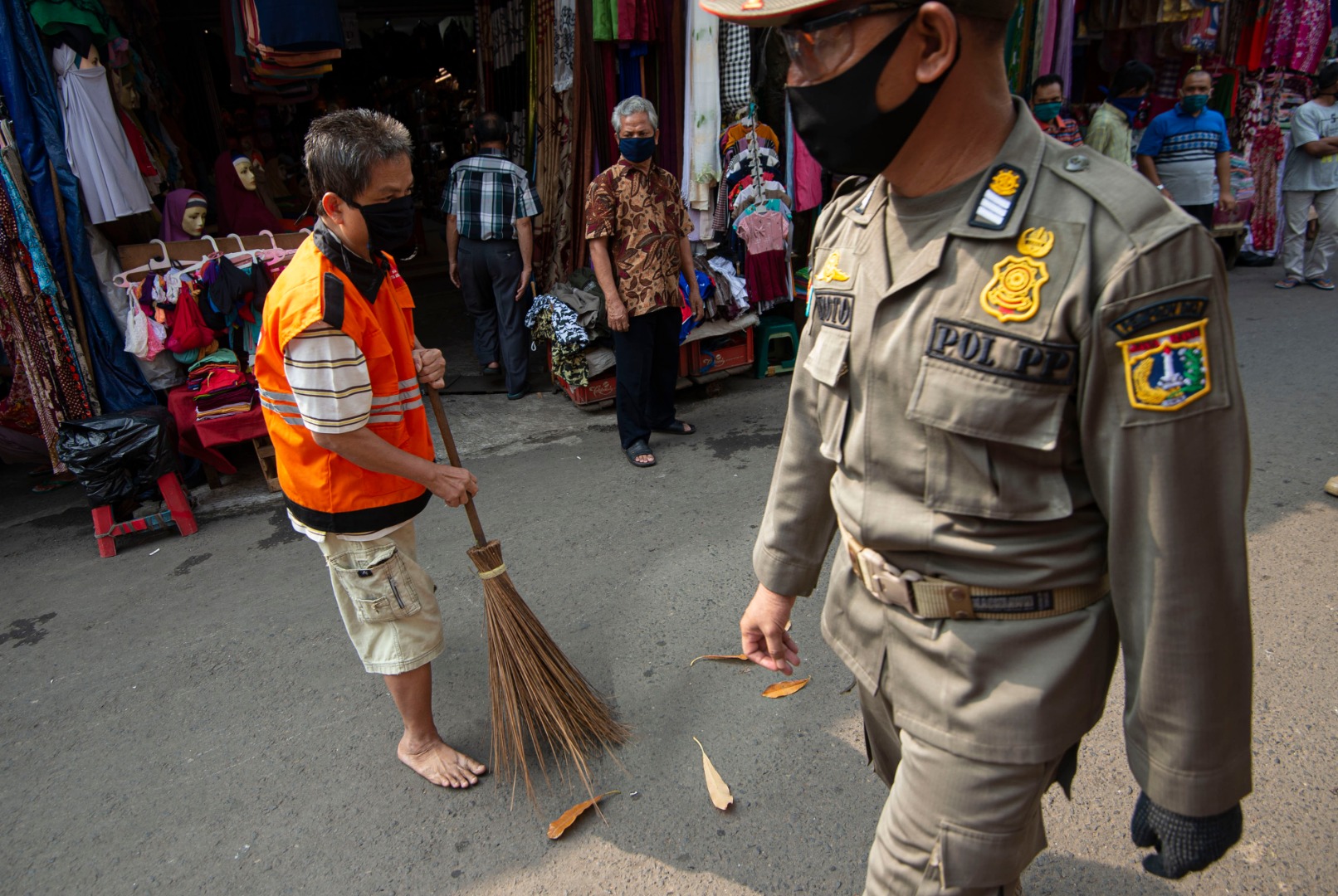  Petugas Satpol PP mengawasi pelanggar aturan PSBB di Pasar Jatinegara, Jakarta.