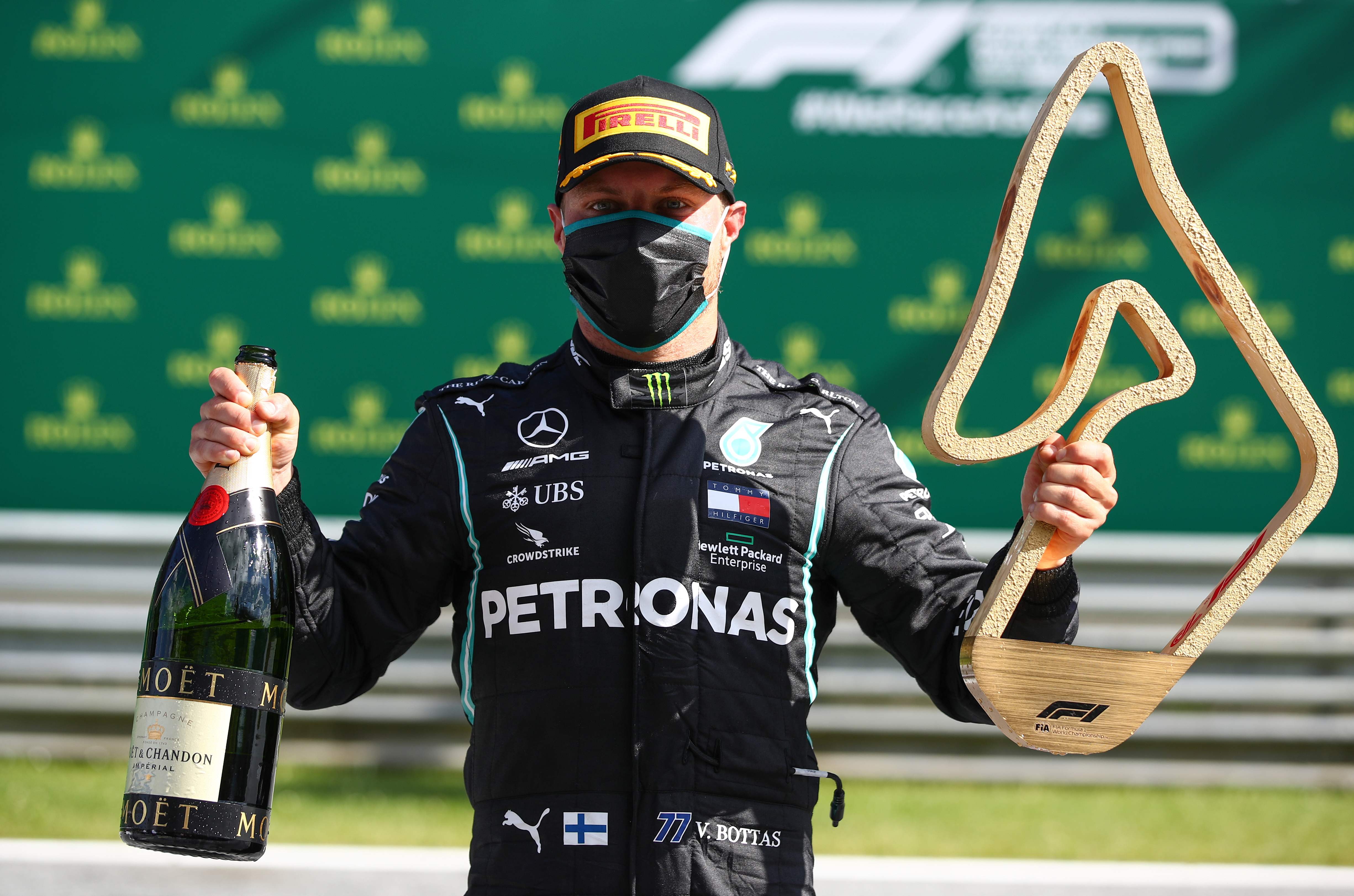 Pebalap tim Mercedes Valtteri Bottas mengangkat tropi dalam kejuaraan Formula One Grand Prix di Spielberg, Austria, Minggu (5/7/2020)