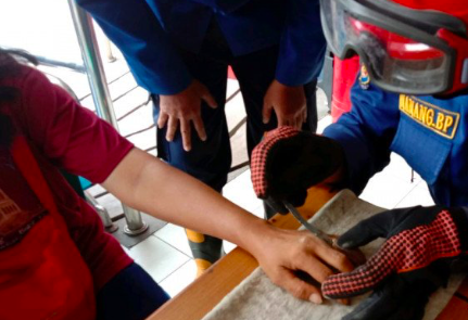 Petugas Damkar Jakarta Selatan melepaskan cincin di jari manis tangan kiri Ibu Lusi di Kantor Damkar Jaksel Sektor Pasar Minggu, Jakarta.