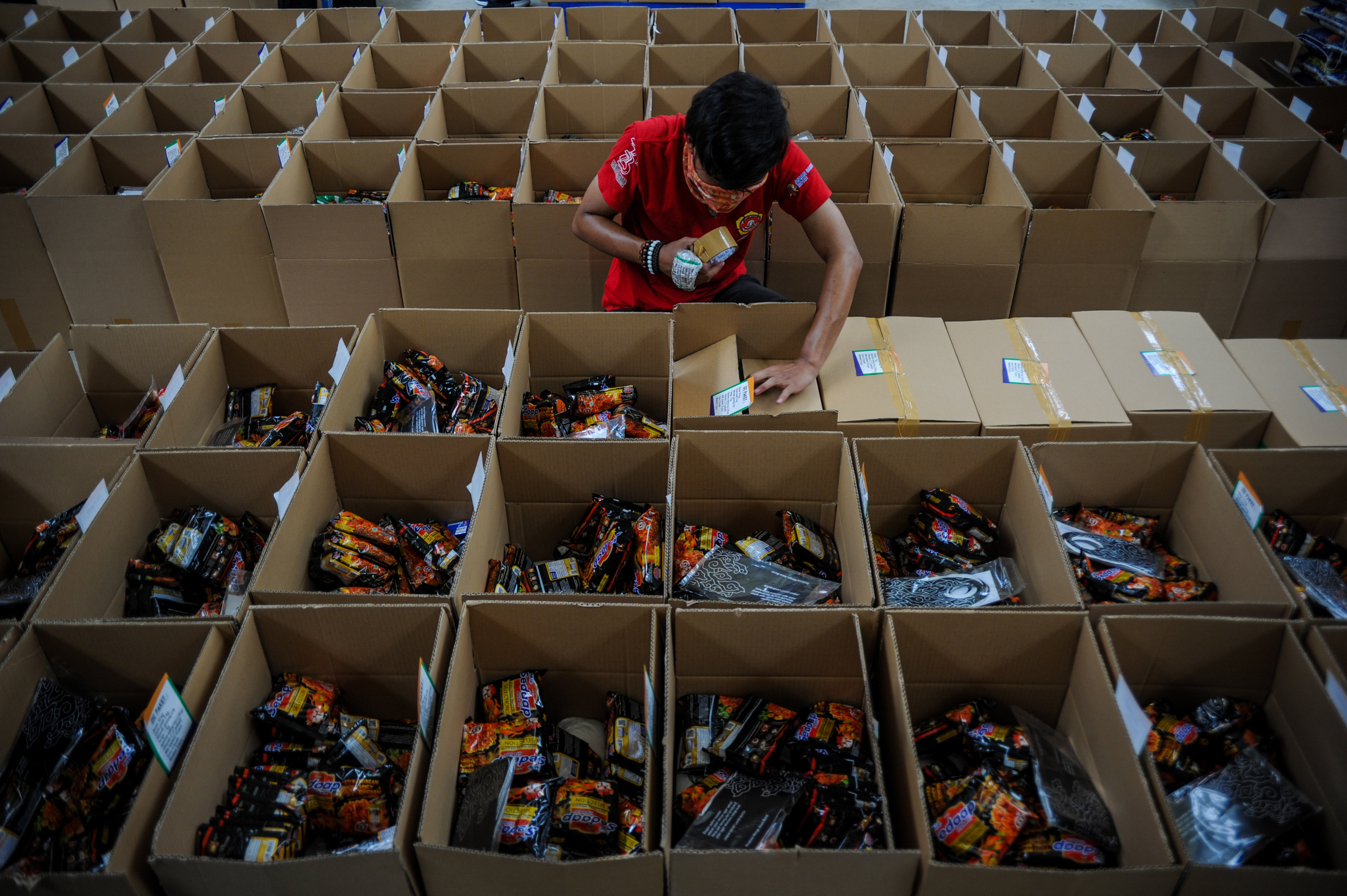 Petugas mengemas sembako bansos dalam satu dus di Gudang milik Perum Bulog di Gedebage, Bandung, Jawa Barat, Rabu (8/7).