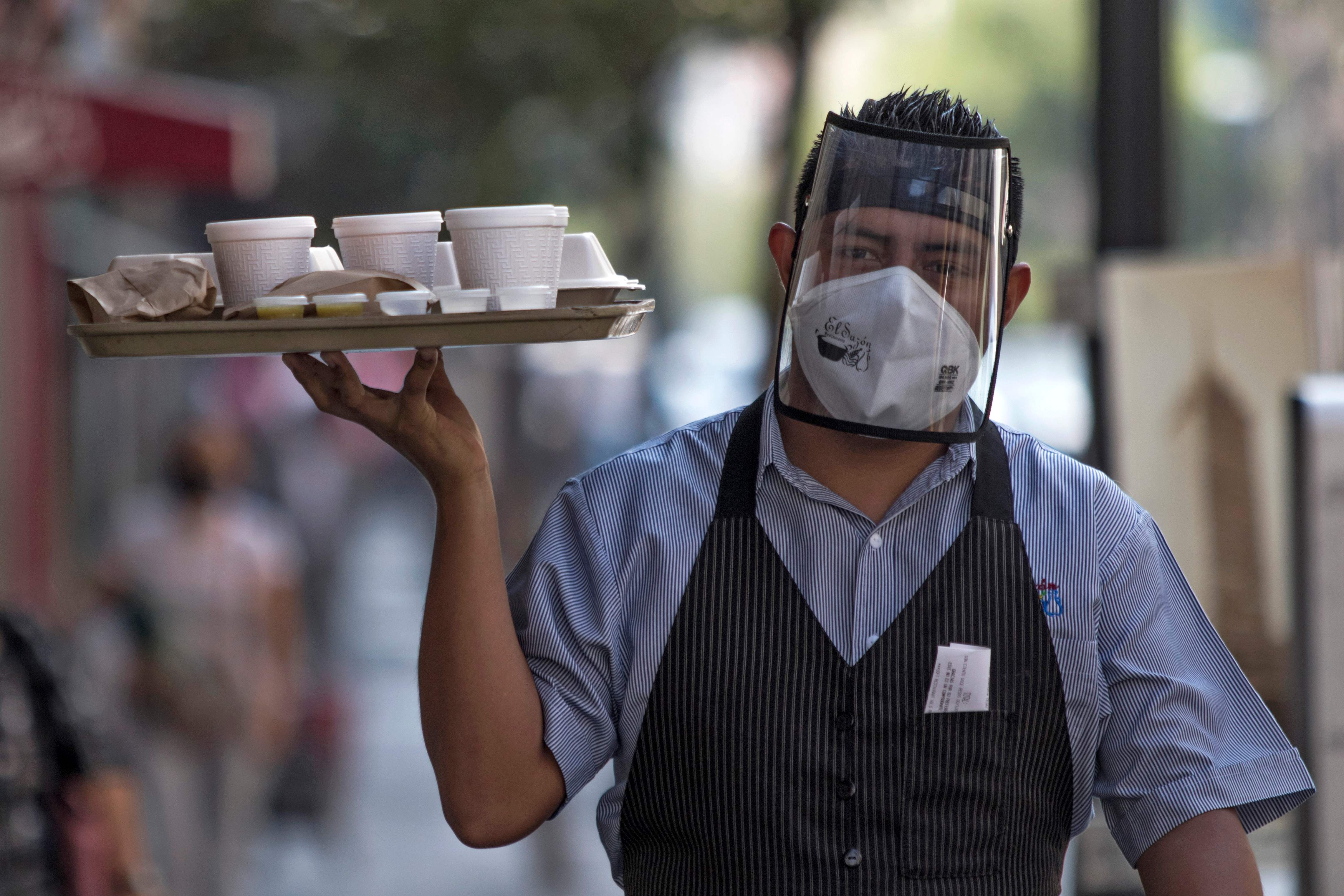 Seorang pekerja restoran mengantarkan pesanan di Mexico City, Meksiko.