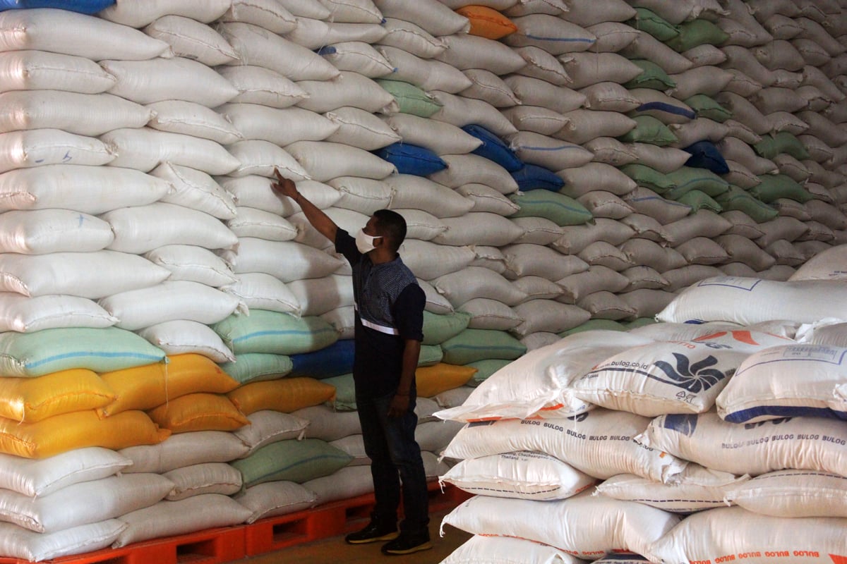 Petugas memeriksa beras di gudang beras milik Bulog Nusa Tenggara Timur (NTT) di Kelurahan Tenau Kupang