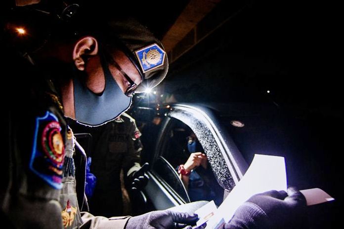 Petugas memeriksa surat izin keluar masuk (SIKM) untuk masuk wilayah Jabodetabek di KM 47 Tol Cikampek-Jakarta.