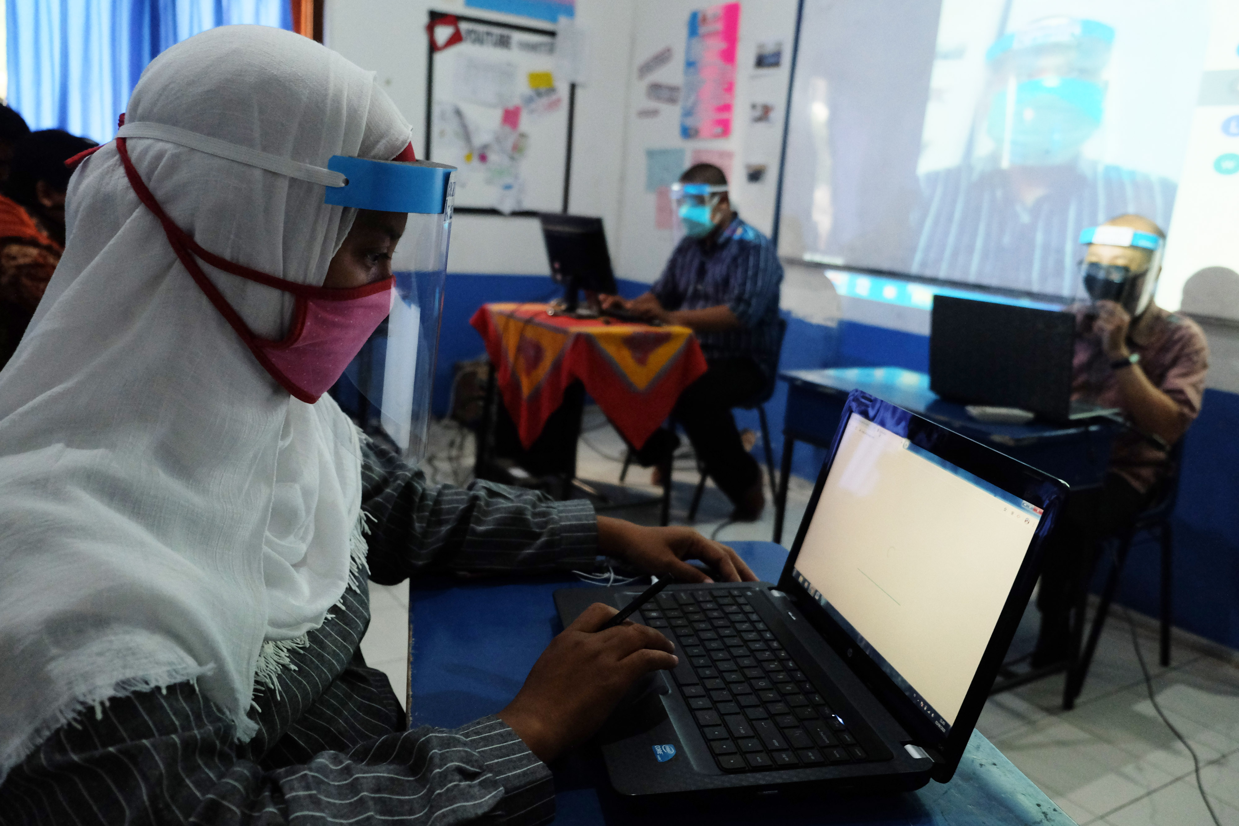 Guru SMP melakukan rapat kelulusan siswa secara daring.