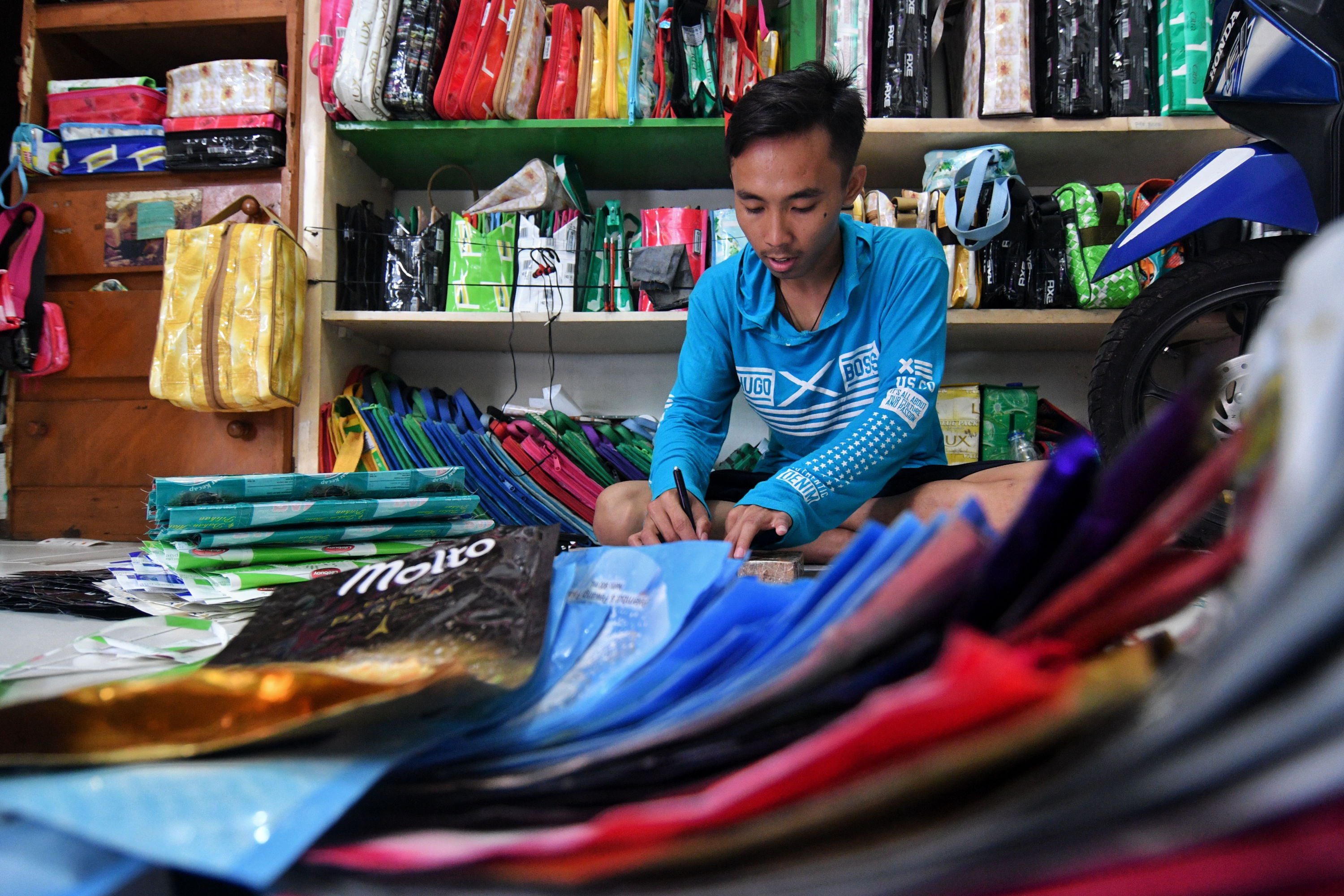 Pekerja menyelesaikan tugasnya disebuah tempat pengelolaan limbah plastik rumahan di Pasar Minggu Jakarta