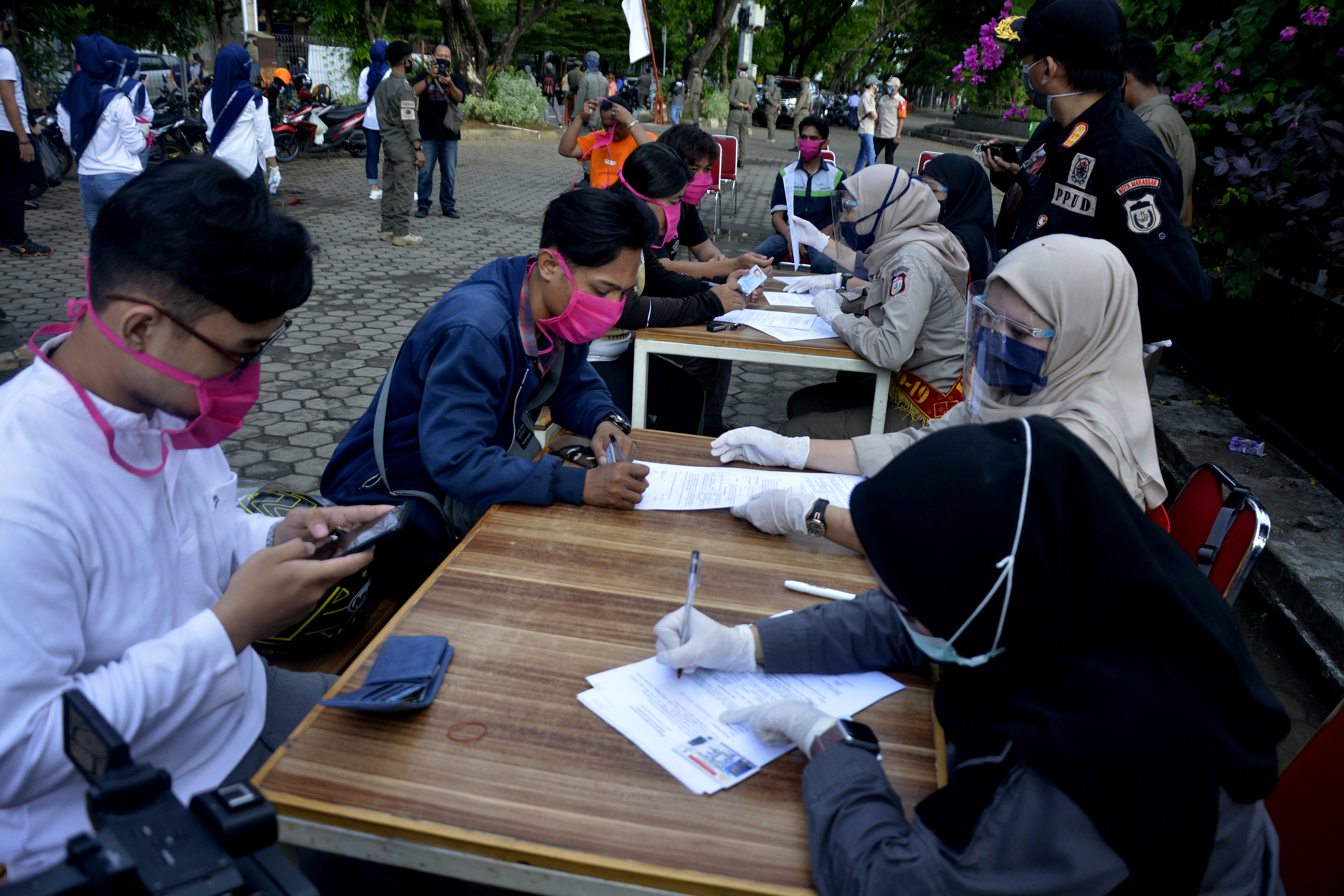 Personel Inspektur covid-19 melakukan sidang cepat kepada warga yang melanggar protokol kesehatan di Anjungan Pantai Losari, Makassar.