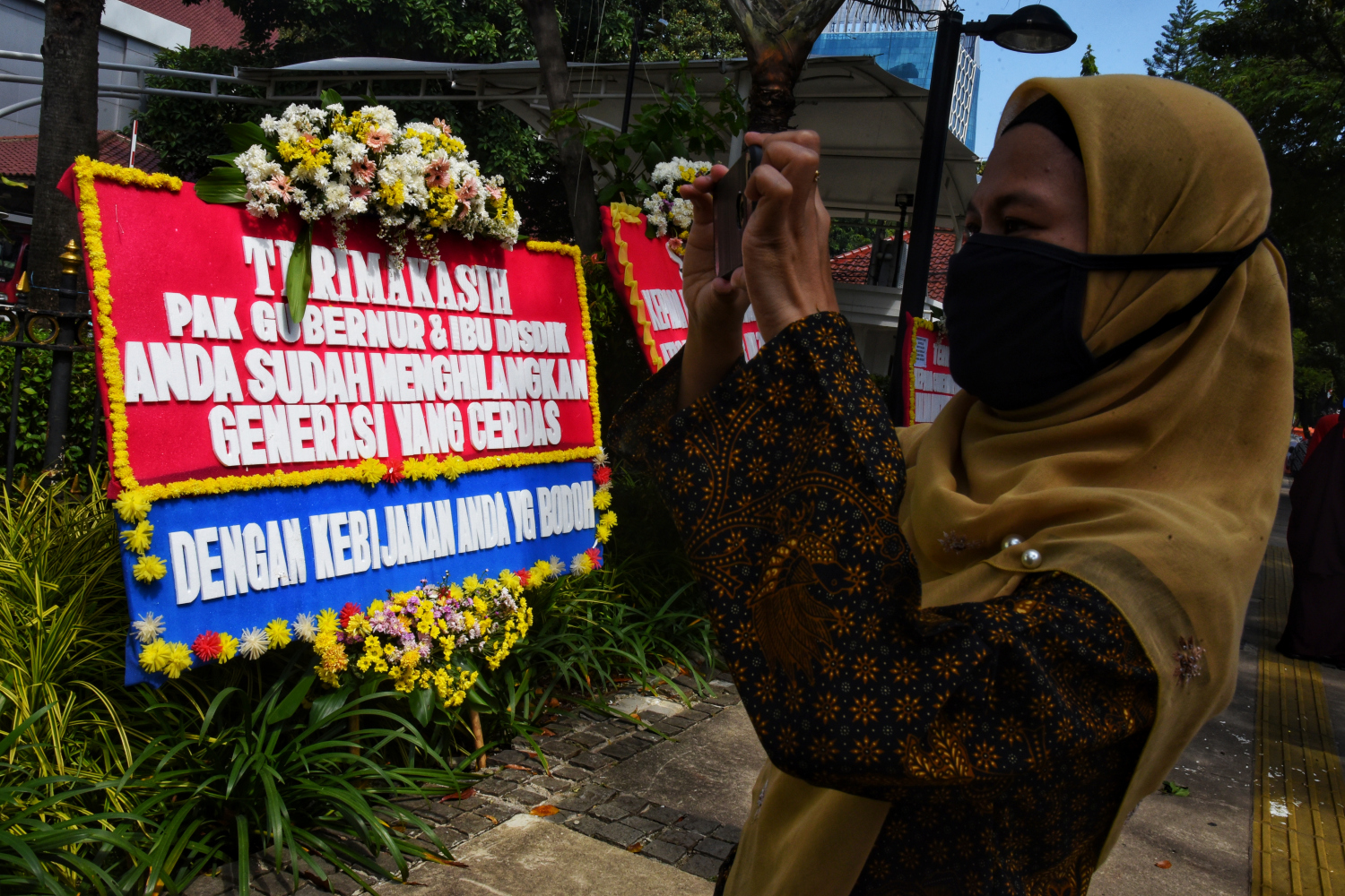 Relawan menata karangan bunga yang terpajang di depan pintu masuk Balai Kota Jakarta, Jalan Medan Merdeka Selatan, Jakarta Pusat.