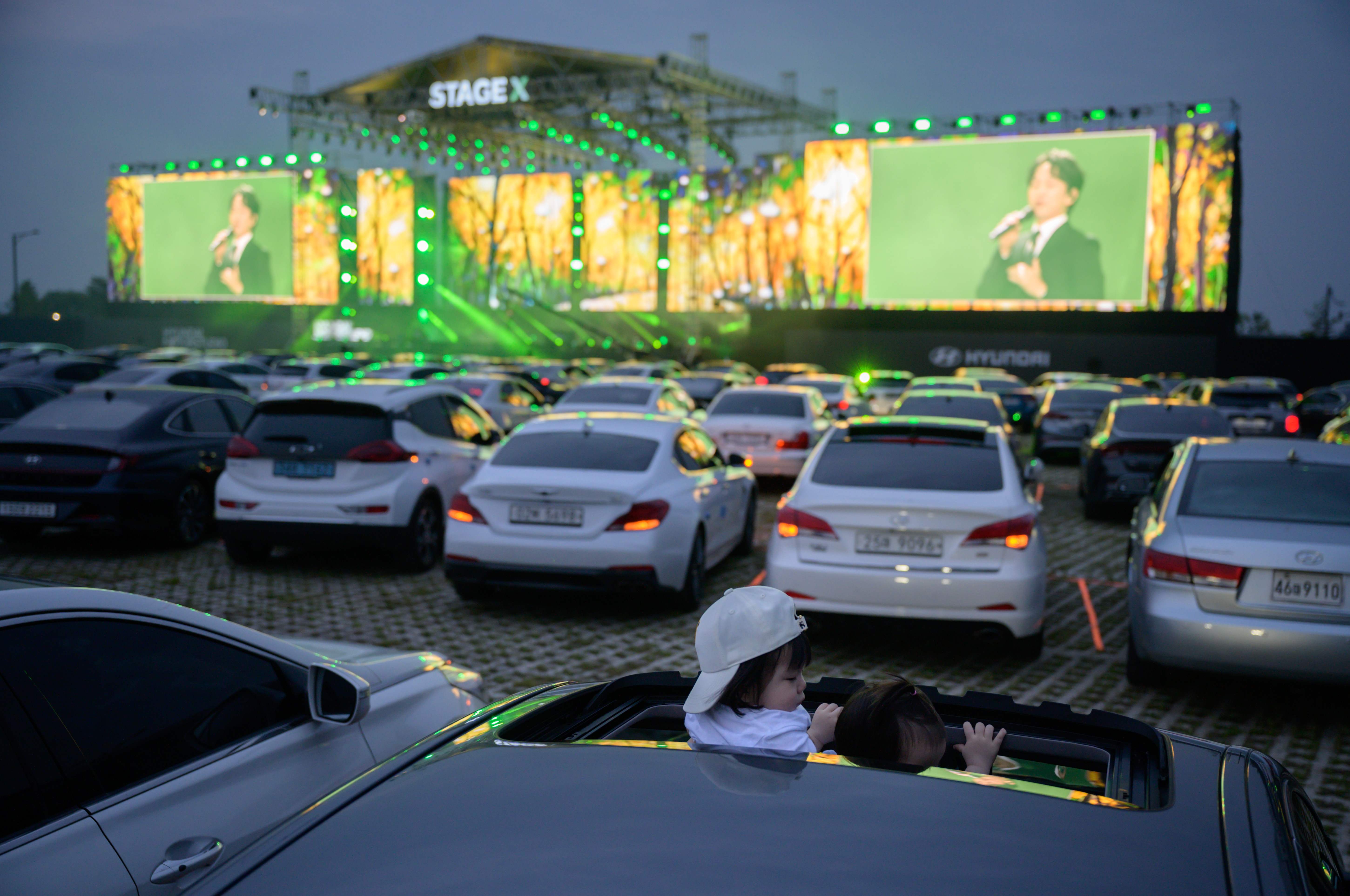 Ilustrasi konser musik yang dinikmati secara drive in.