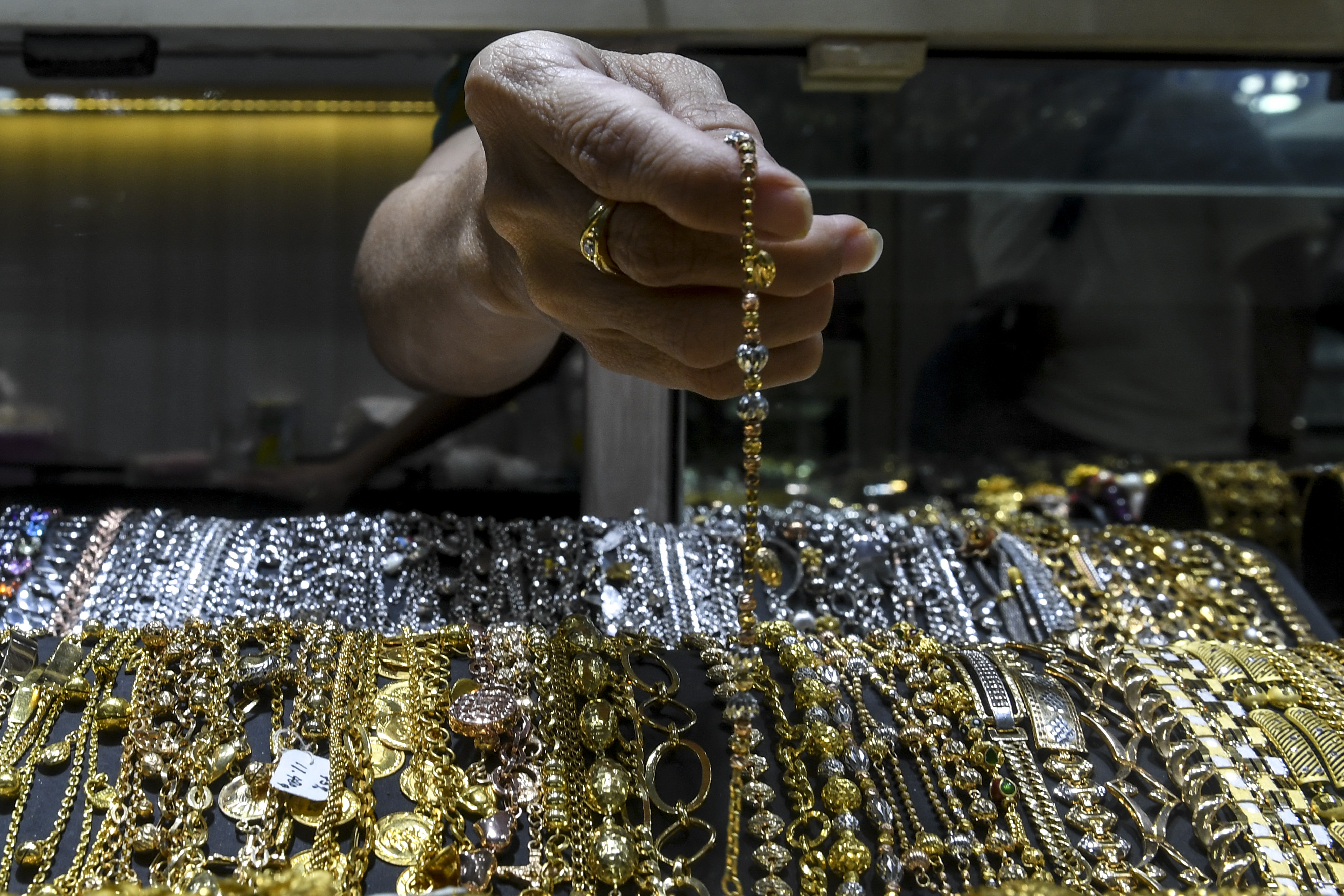 Pemilik toko emas menata perhiasan emas miliknya di Pusat Toko Emas Cikini, Jakarta.