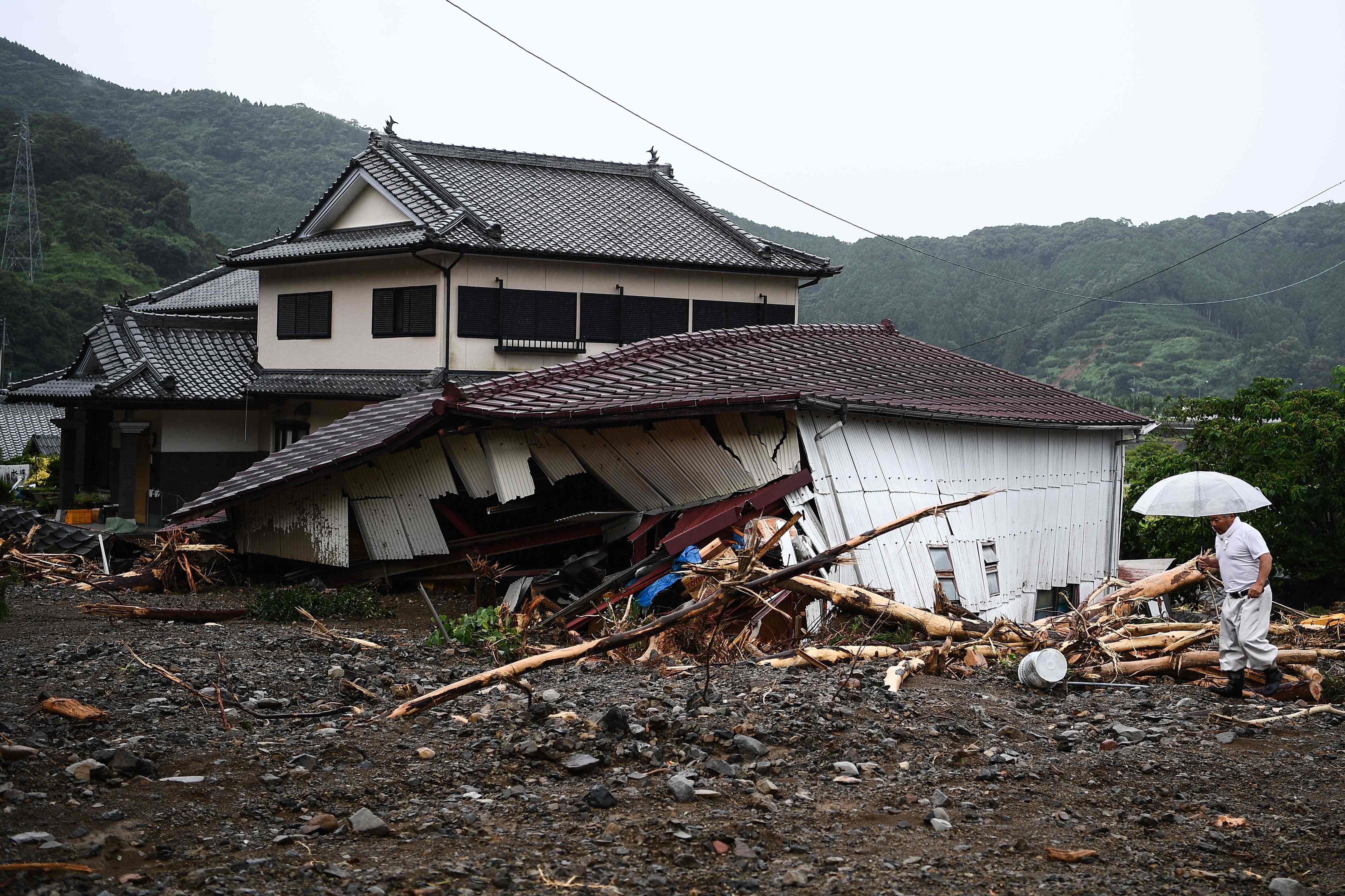 Seorang pria berjalan di lokasi tanah longsor yang disebabkan oleh hujan lebat di Tsunagi, Prefektur Kumamoto pada 7 Juli 2020.