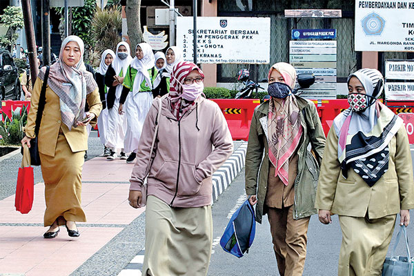GAJI KE-13 PNS: Pegawai negeri sipil (PNS) Kota Depok memakai masker saat jam pulang kantor di Balai Kota Depok, Jawa Barat, Selasa (3/3). 