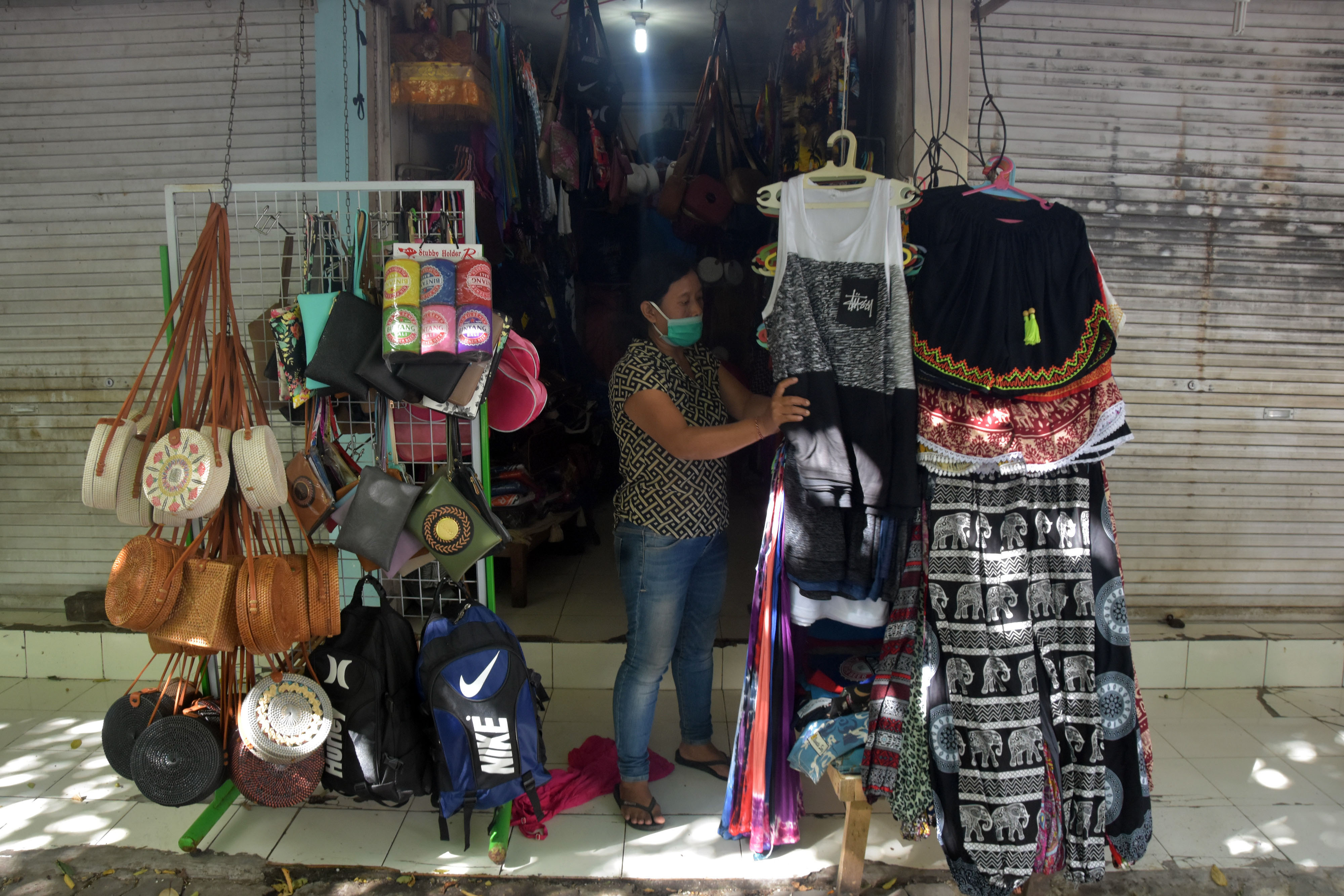 Pedagang menyiapkan barang dagangannya di Pasar Seni Kuta, Bali.