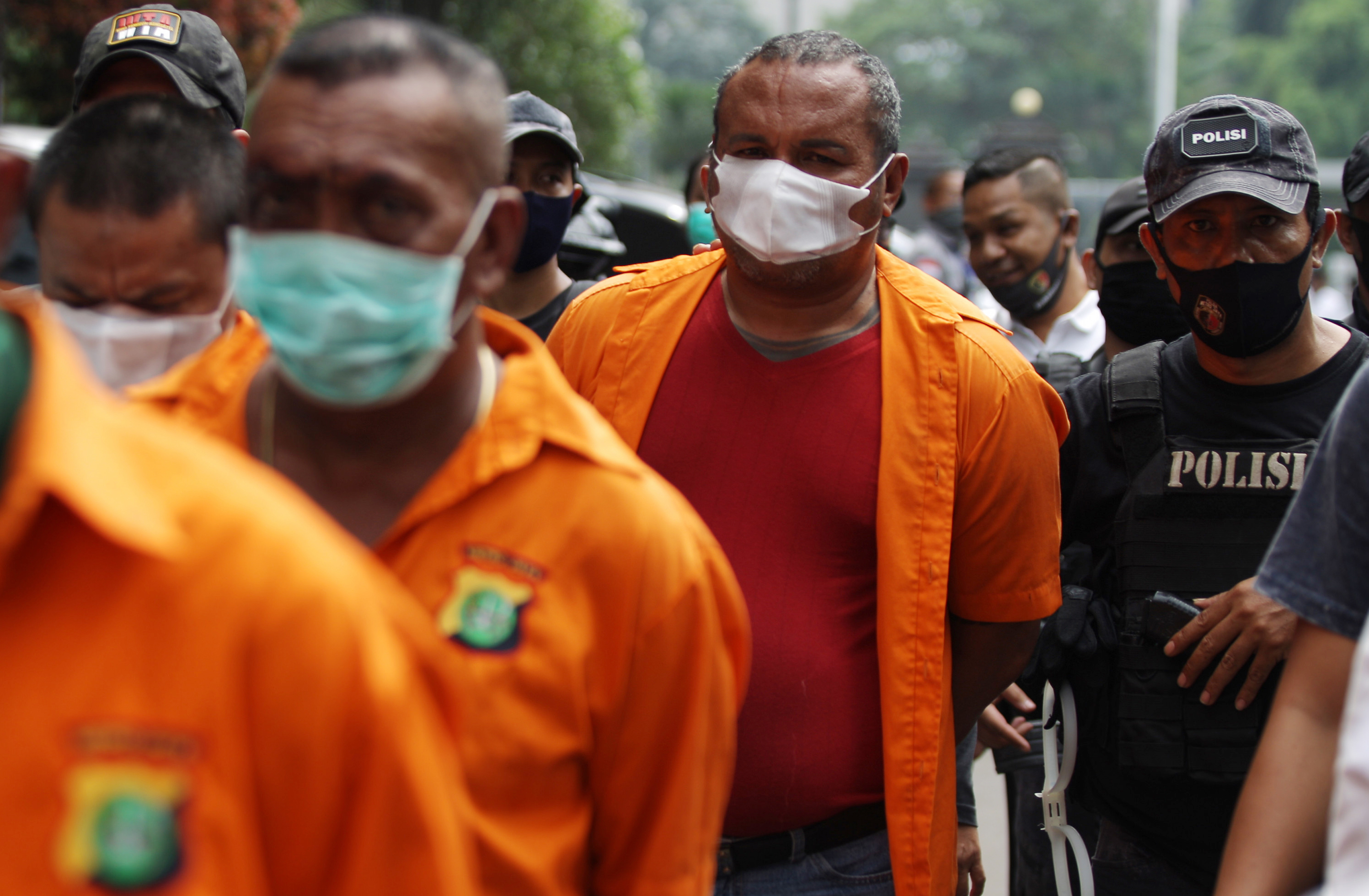 Polisi membawa salah satu tersangka pembunuhan berencana, John Kei (kaus merah)