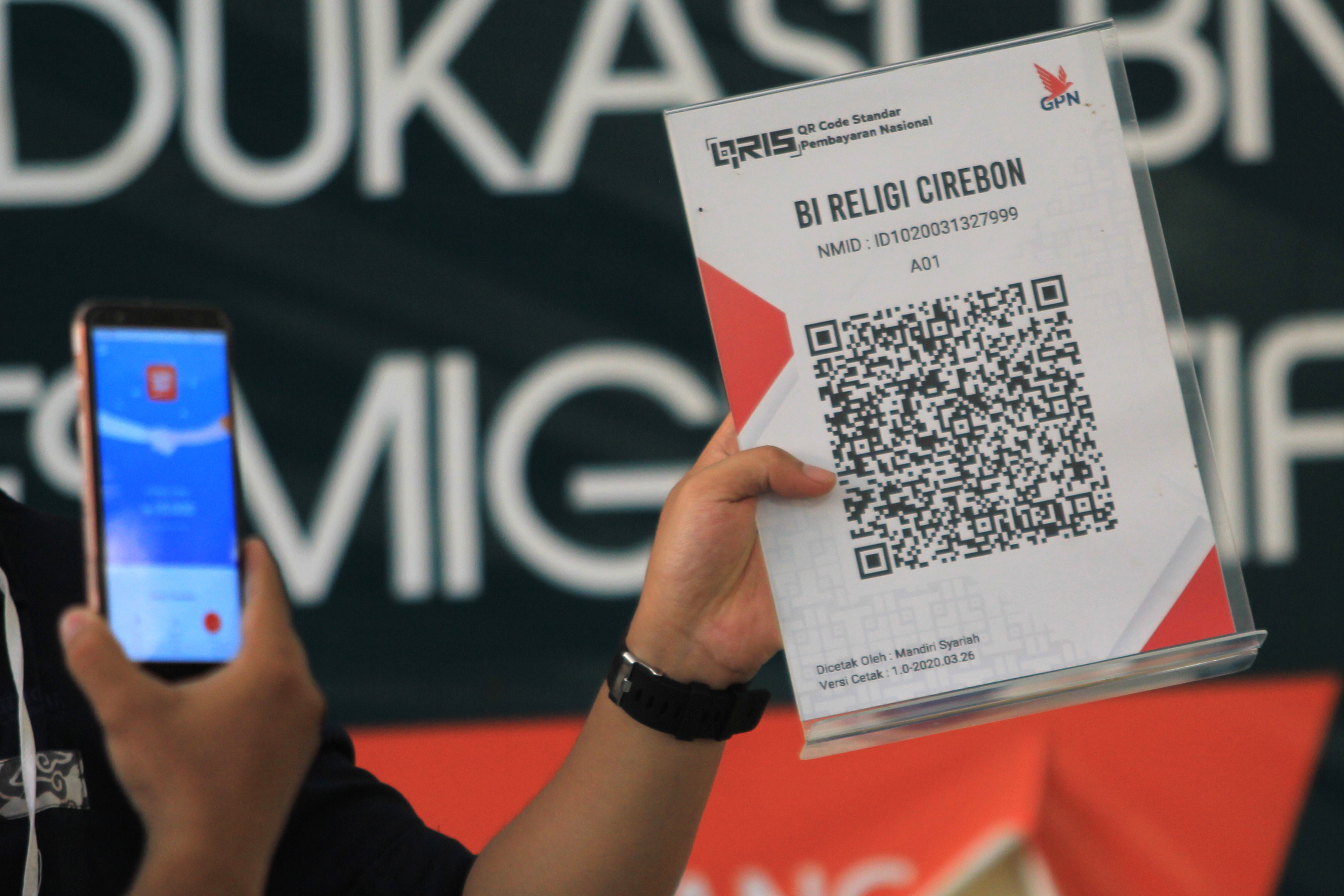Karyawan Bank Indonesia Cirebon menjelaskan kepada pelaku UMKM tentang aplikasi uang elektronik di Desa Kenanga, Indramayu, Jawa Barat.