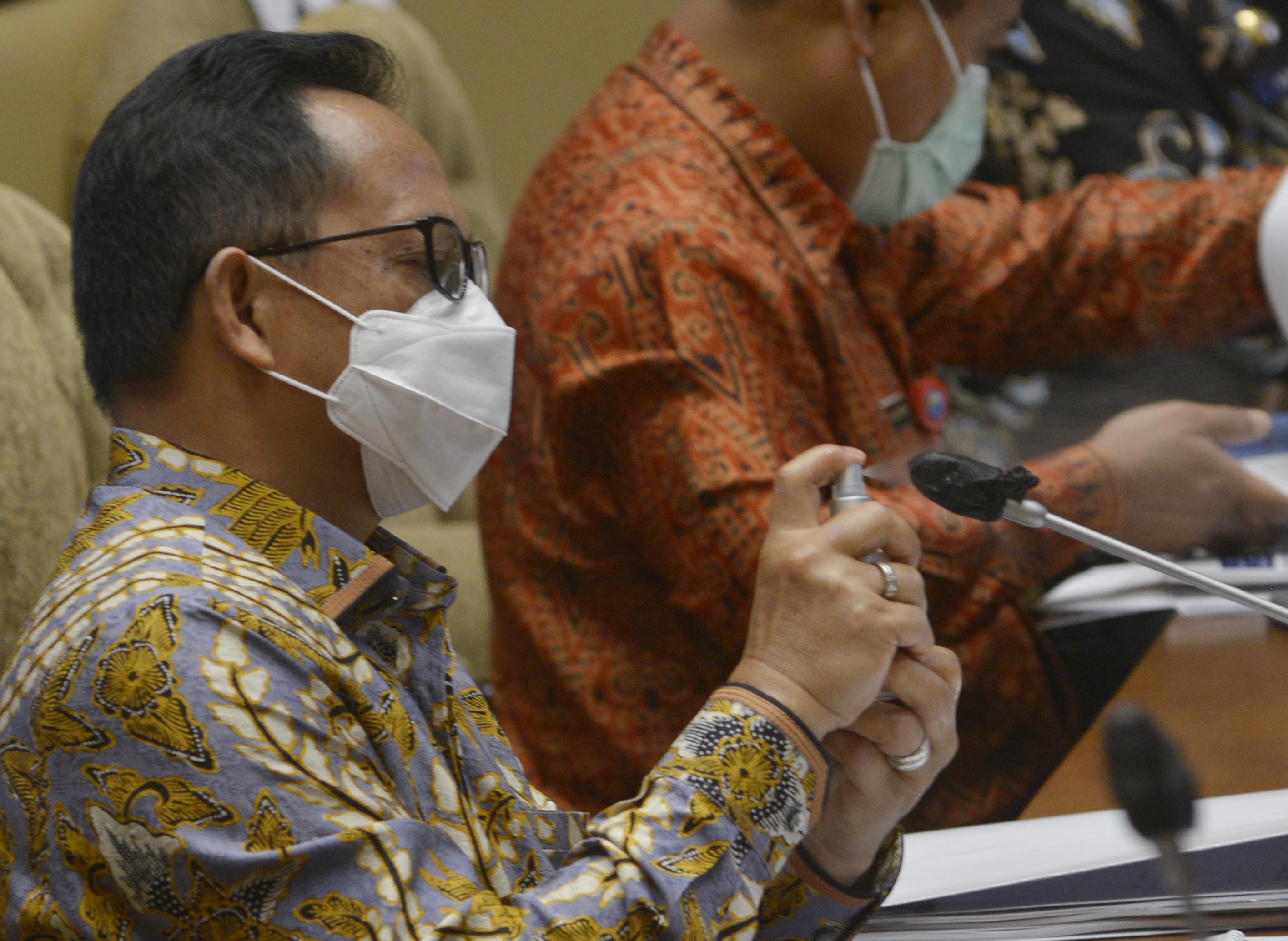Mendagri Tito Karnavian menyemprotkan cairan pembersih kuman sebagai standar protokol kesehatan saat rapat kerja dengan Komisi II DPR RI.