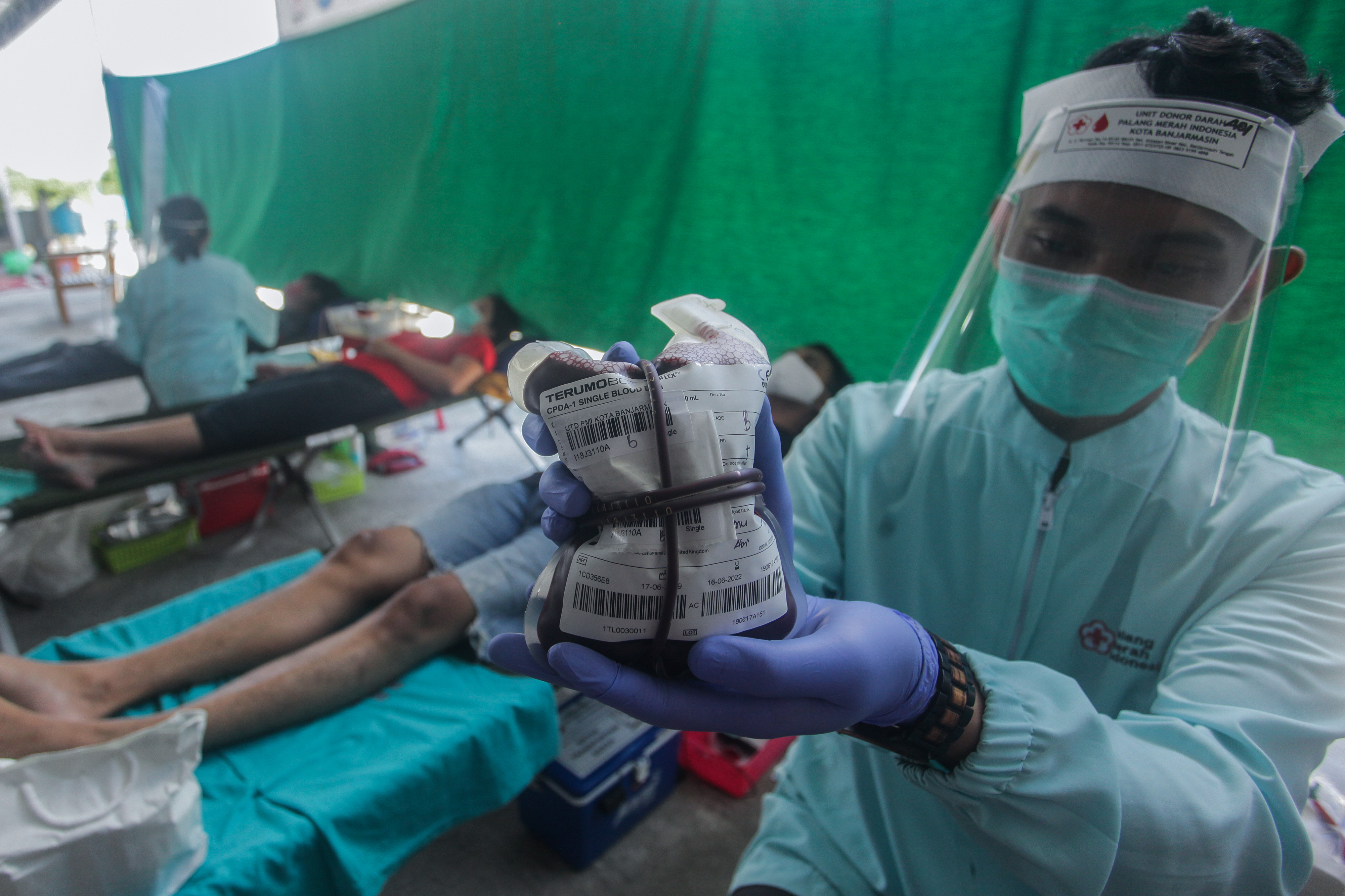 Petugas menunjukkan kantong berisi darah pendonor saat kegiatan bakti sosial warga untuk membantu stok kantong darah PMI Banjarmasin 