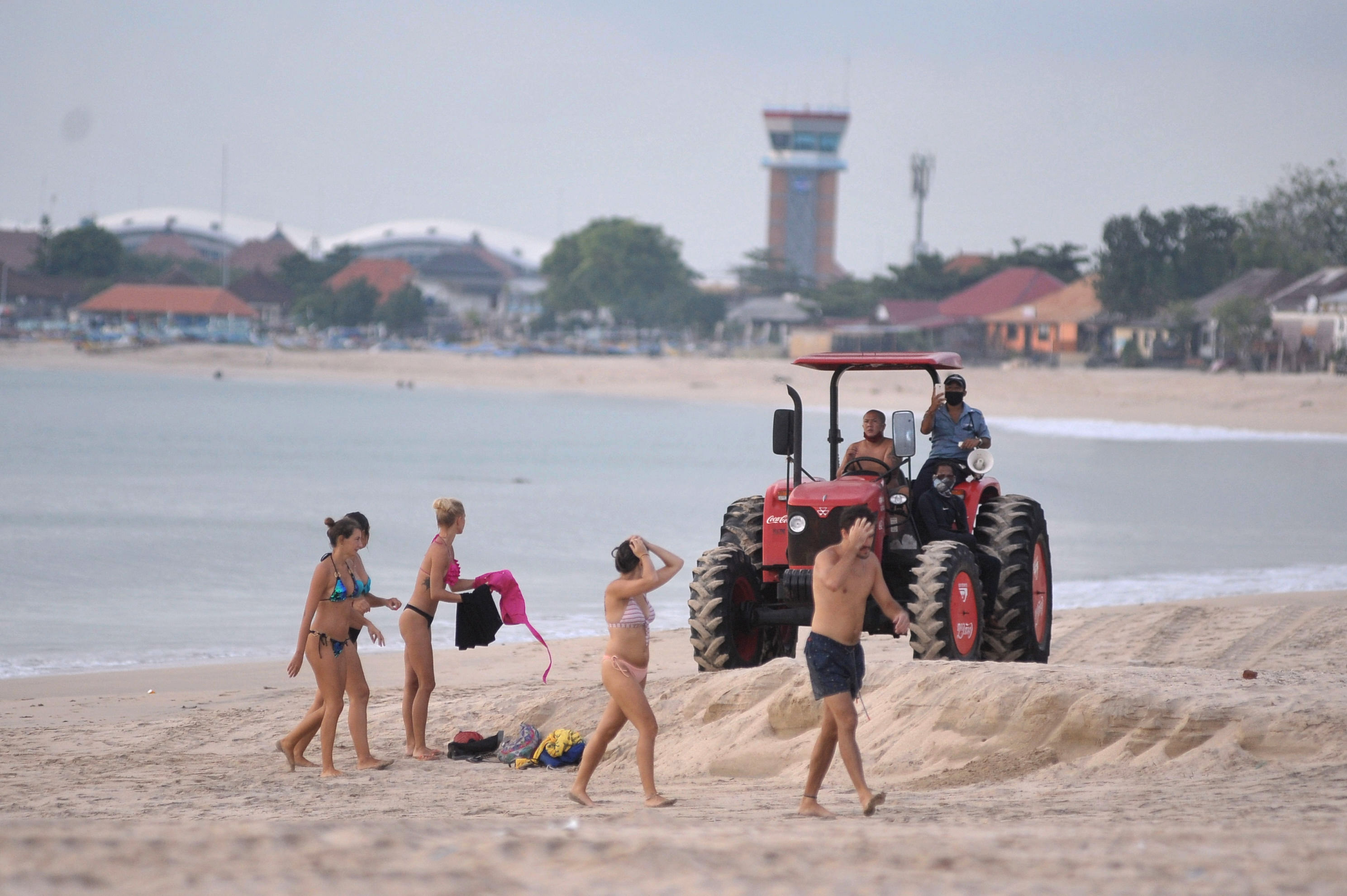 Petugas menghalau wisatawan di Bali di awal pandemi Covid-19, kini Bali menerima wisatawan dengan sejumlah syarat.