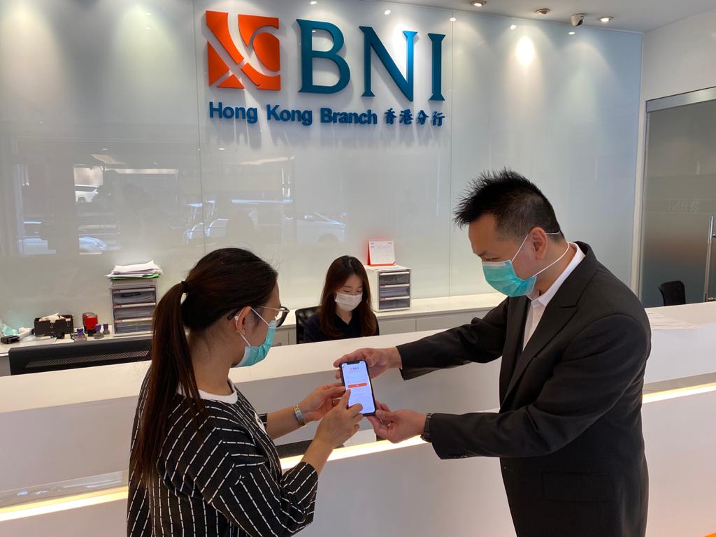 Pegawai sedang membantu nasabah untuk melakukan aktivasi BNI Mobile Banking di Kantor Cabang BNI Hong Kong.